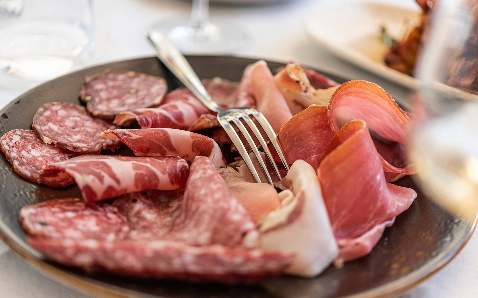 Italian cured meats platter with fork on a Food & Wine Tour in Rome.