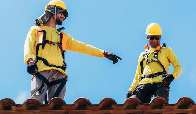 Workers in yellow uniform on the roof
