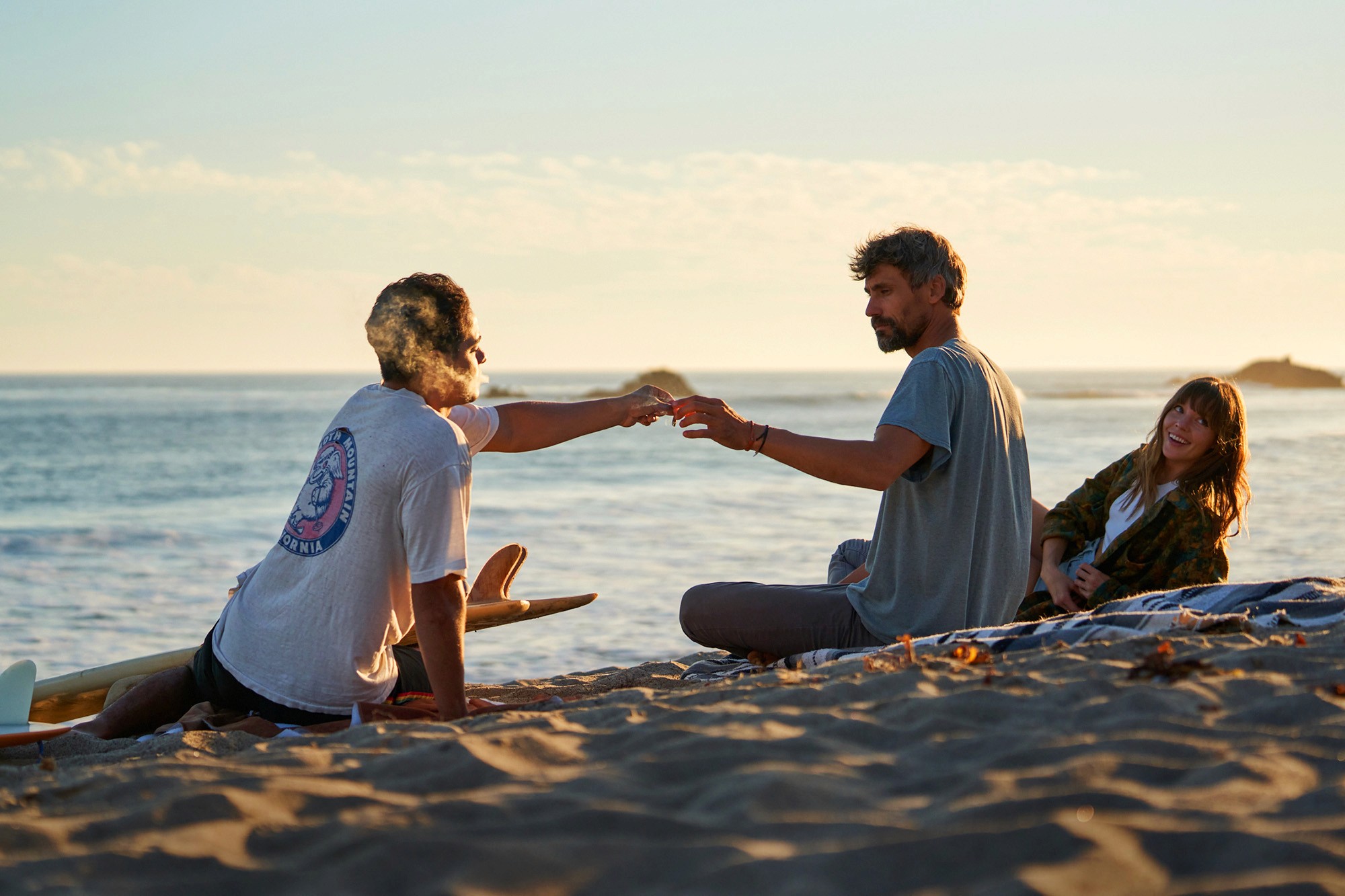 Friends passing joint on beach
