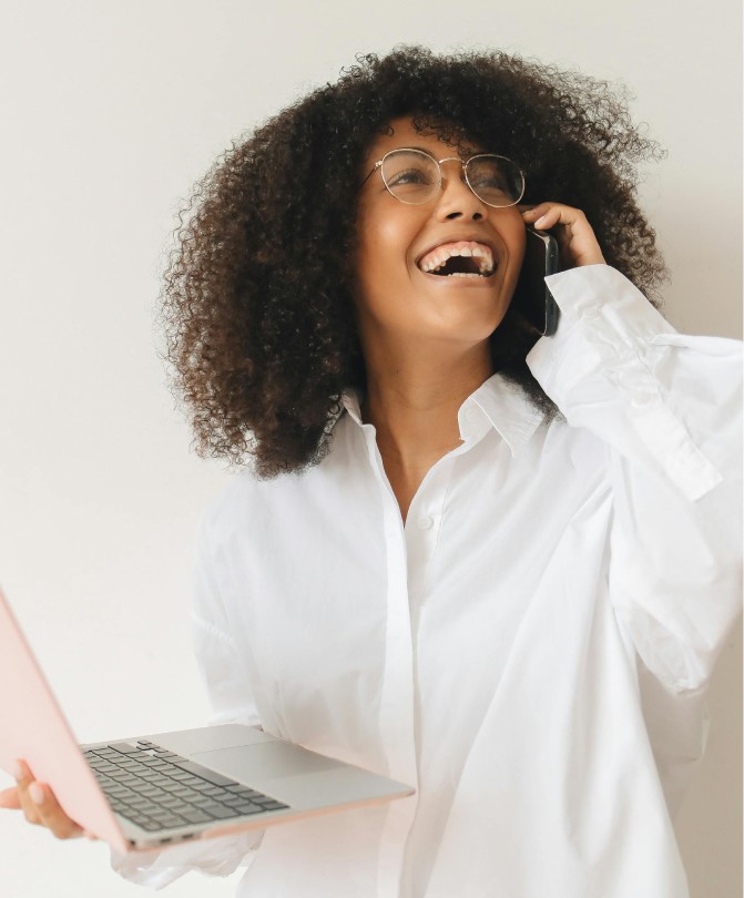 Portrait of a laughing person with curly hair wearing a white shirt