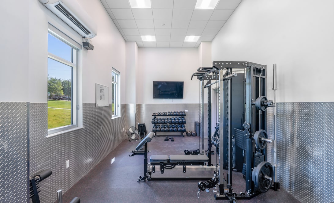 Fitness room with free weights and strength equipment at Hewitt Fire Station 2, by Martinez Architects