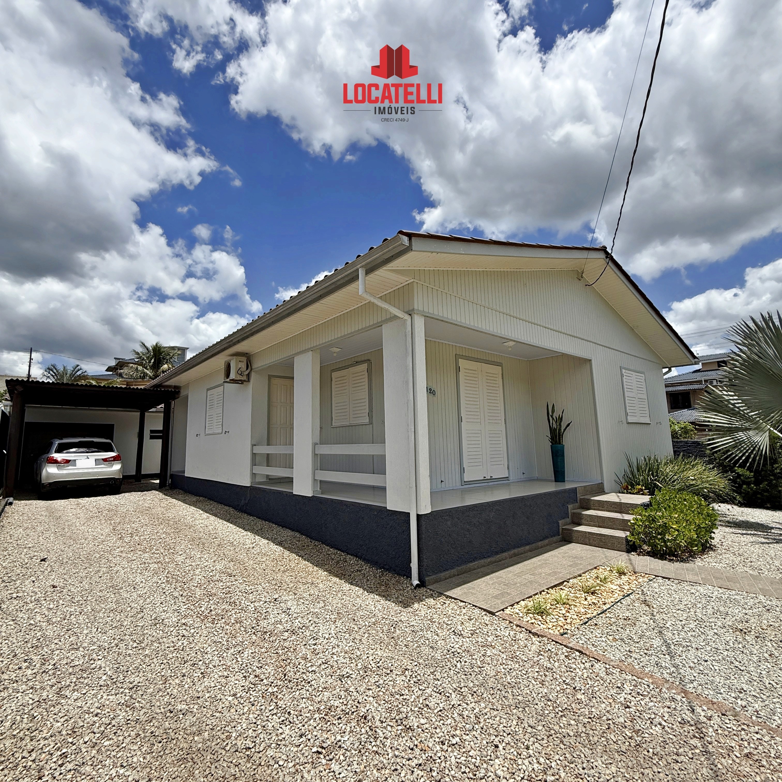 A modern brick house with a two-car garage, well-manicured lawn, and clear blue sky in the background.