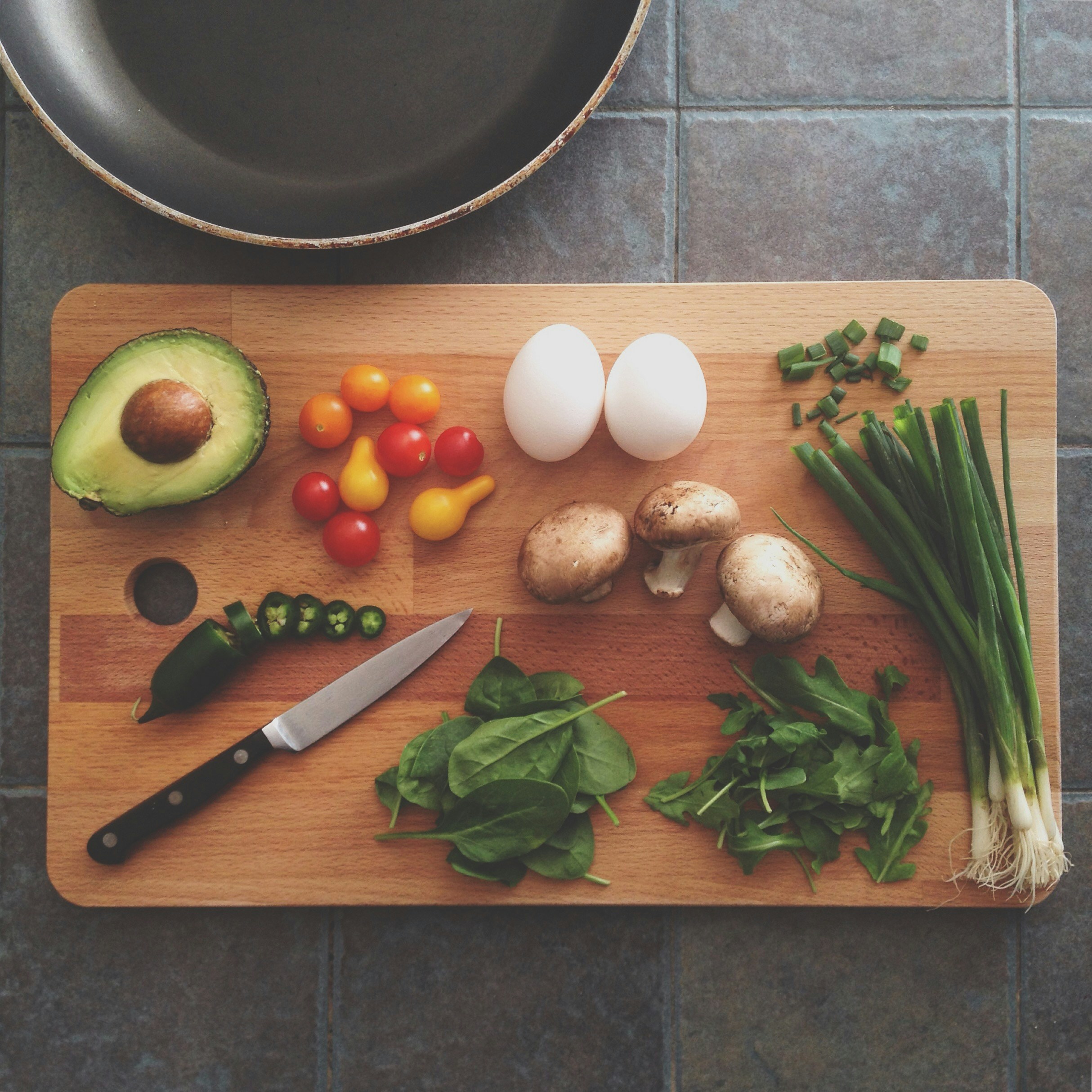 A picture of a cutting board with a lot of vegetables and on it.