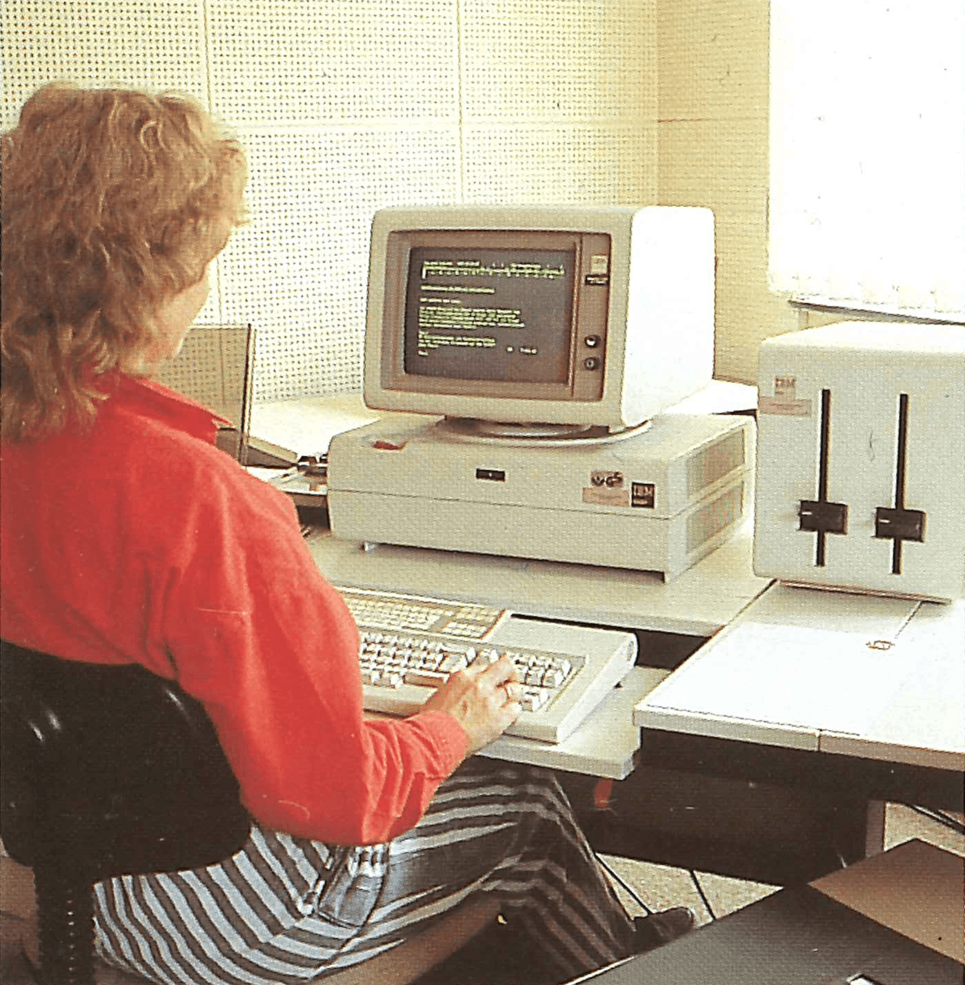 Frau arbeitet an altem Computer mit Tastatur. 80er Jahre Technologie.