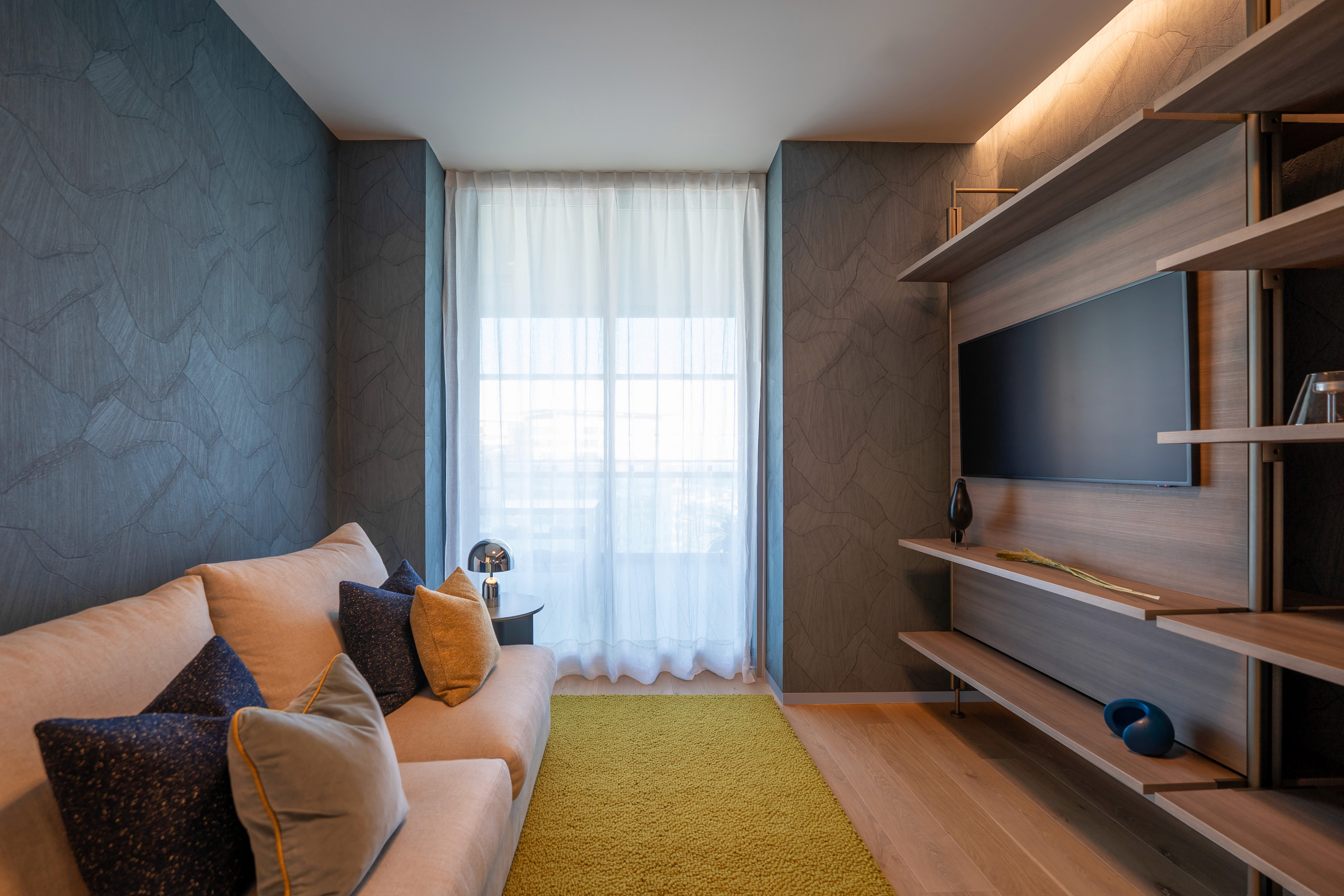 Sala de TV con sofá en tonos oscuros