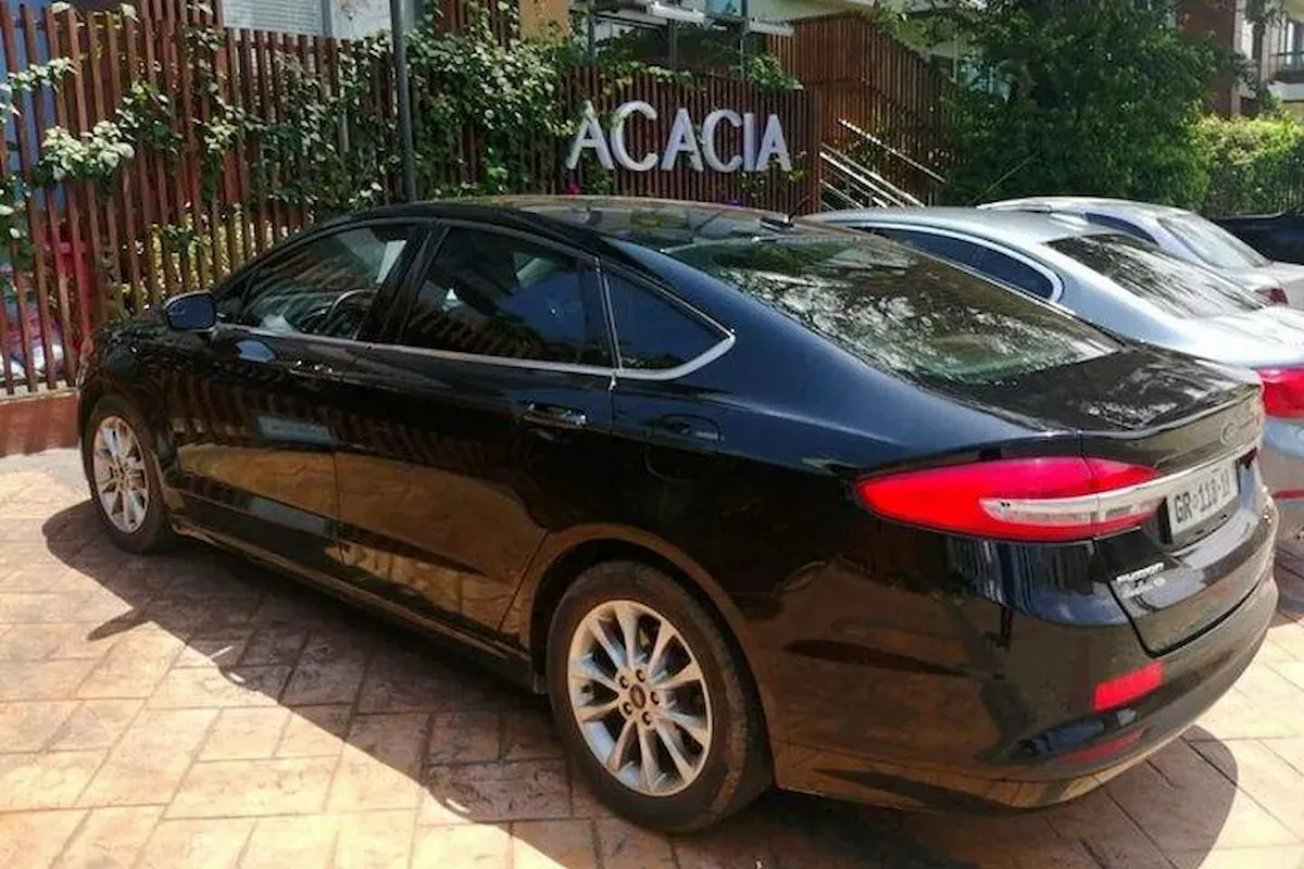 Luxury sedan waiting at a hotel entrance in Accra.