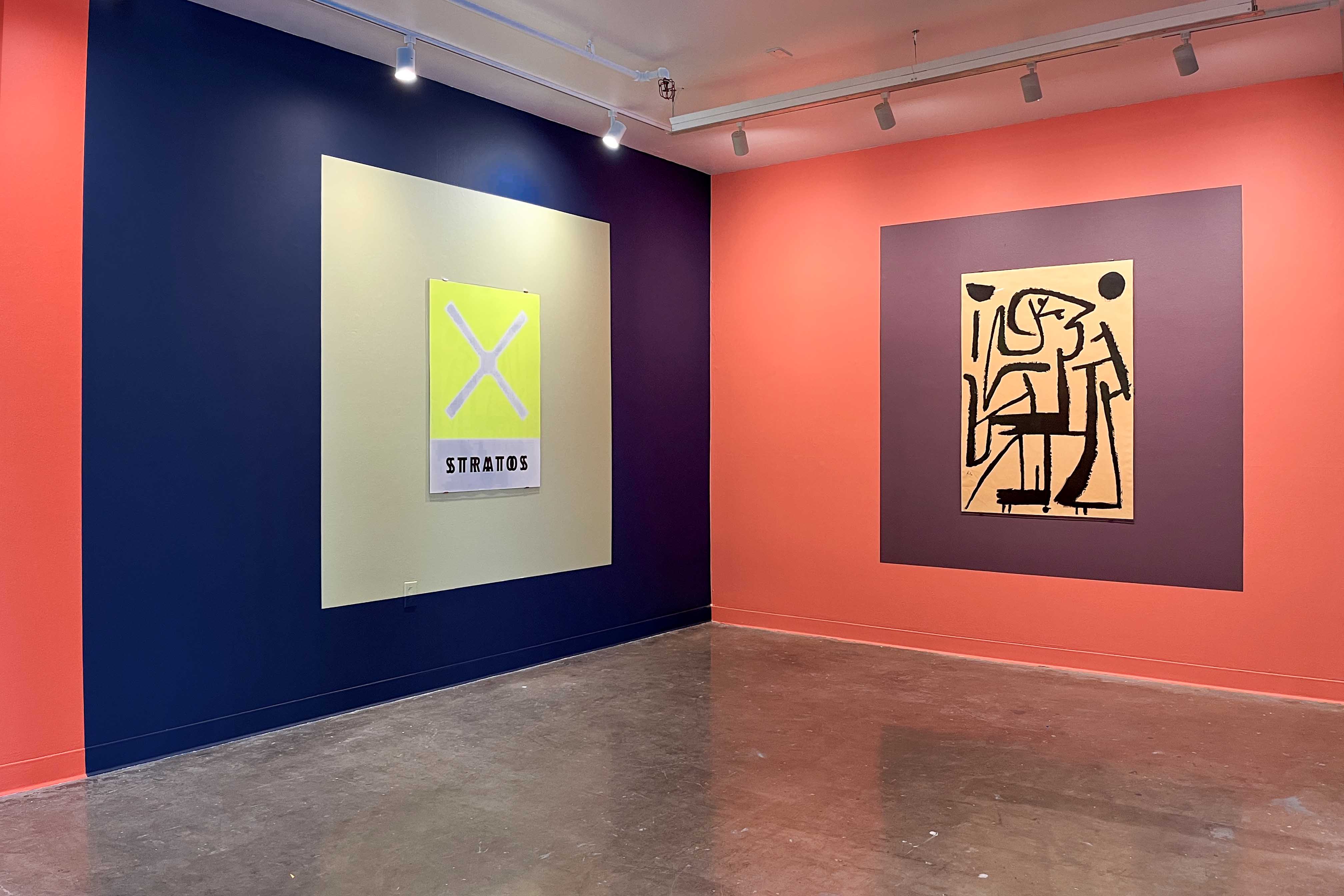 Installation view of two posters displayed on contrasting painted gallery walls.