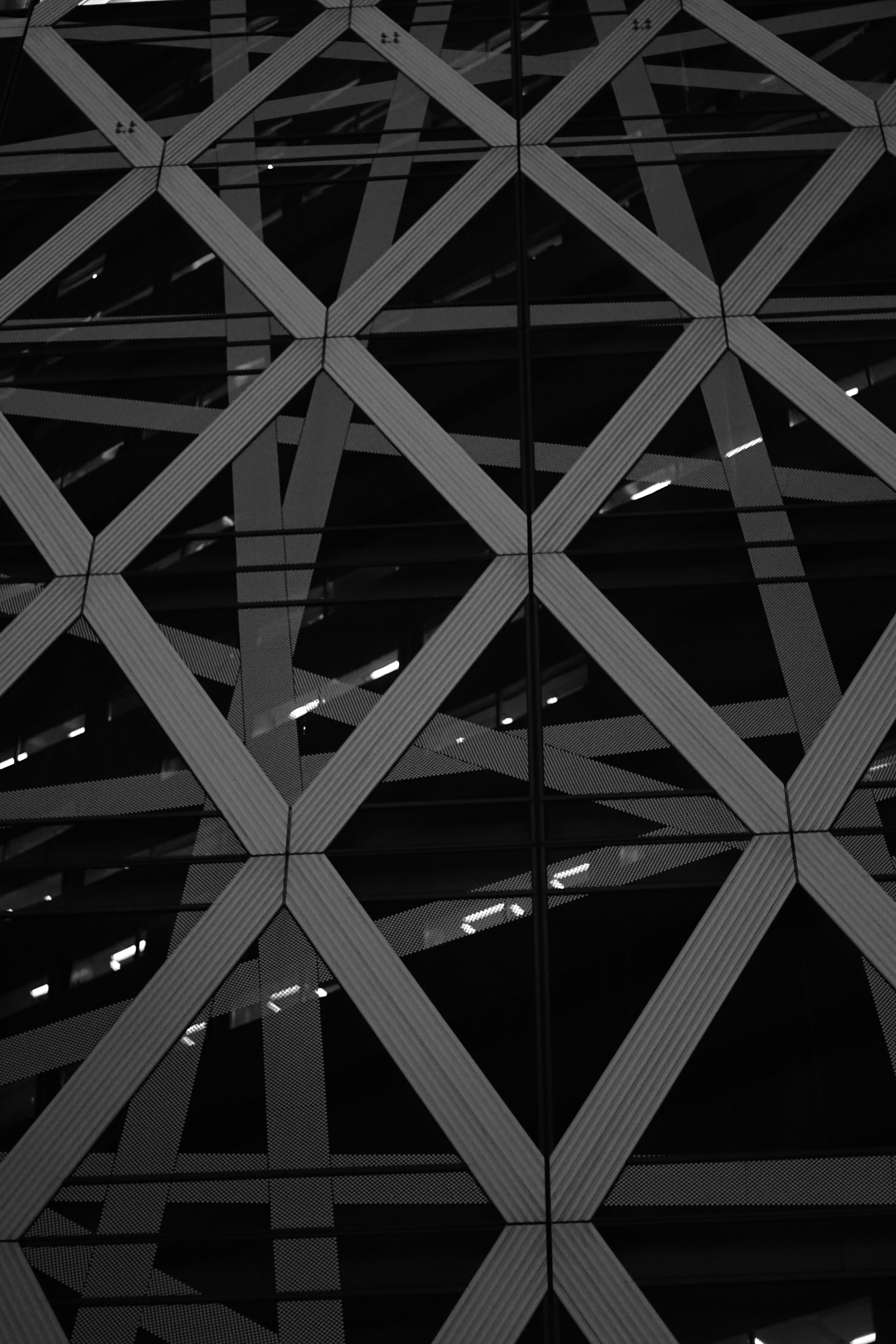 A winding road cuts through rocky terrain, surrounded by patches of green grass and illuminated by sunlight.