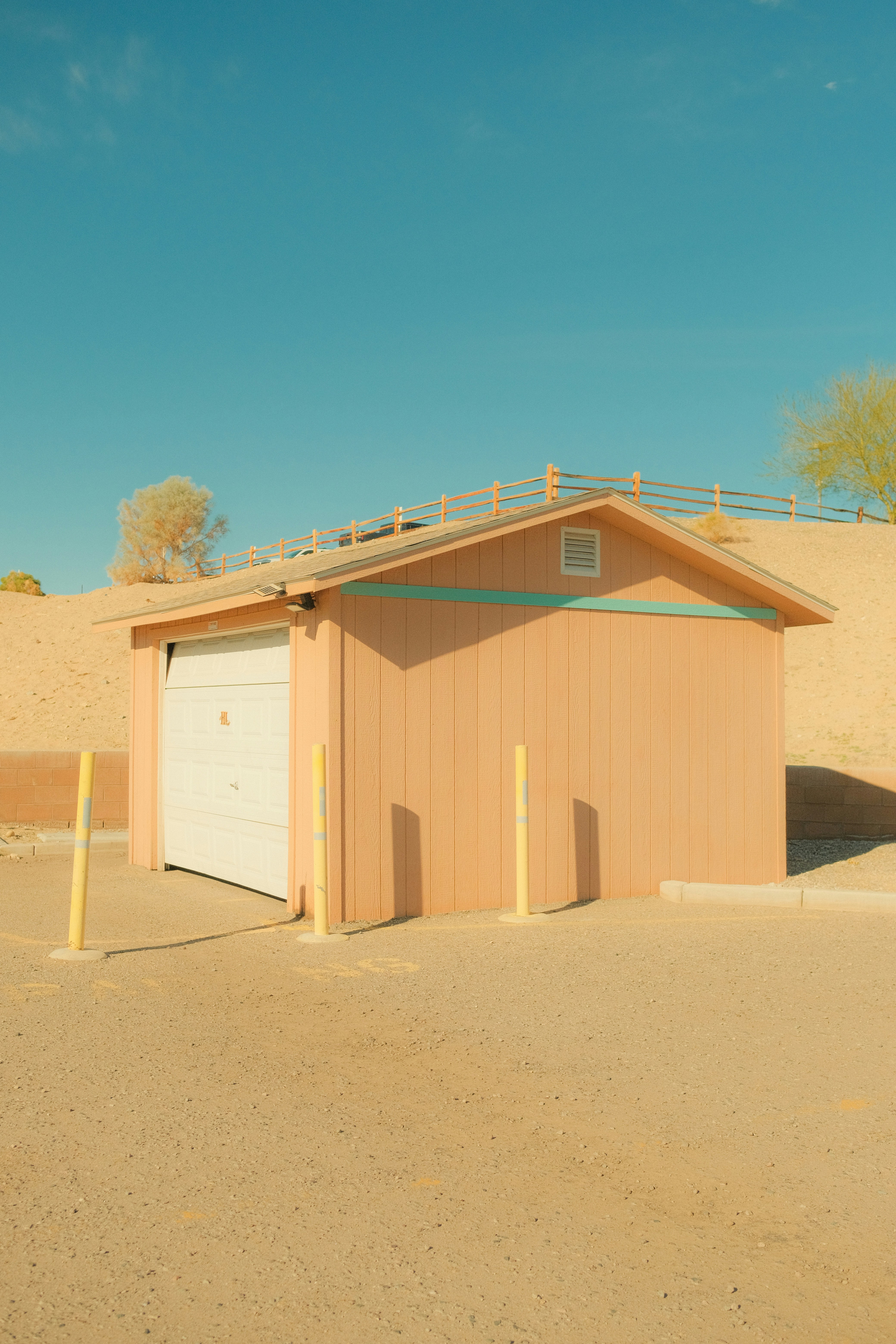 A small peach-colored building with a garage door.