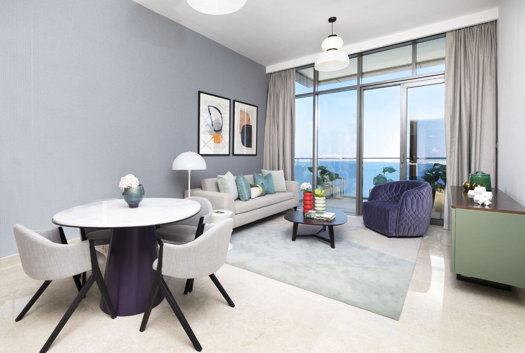 Contemporary living room with a large window, allowing ample sunlight and showcasing elegant design in Anwa Omniyat Maritime City.