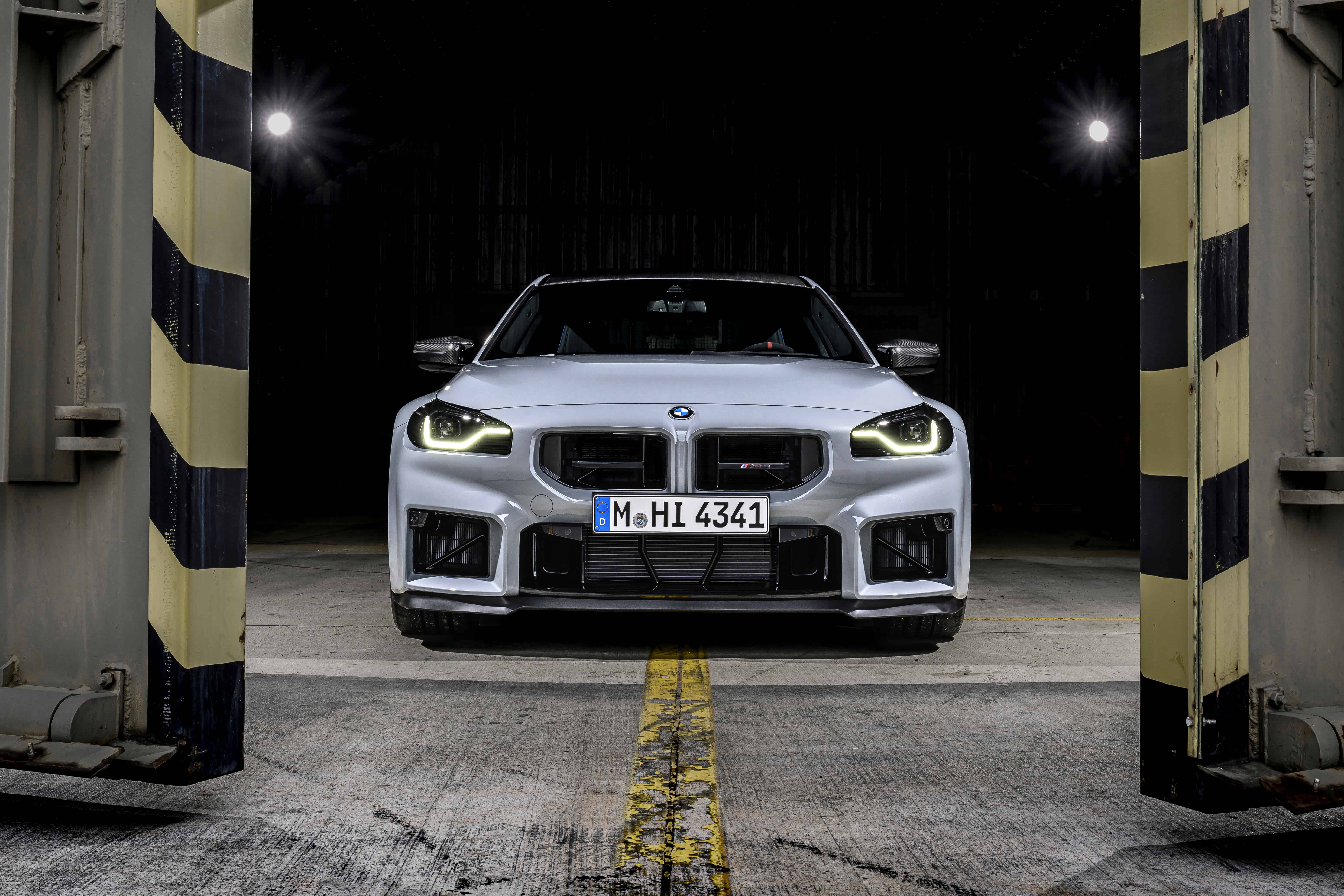 Front view of the BMW M2 CS positioned inside an industrial garage environment