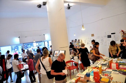 A group of people looking at different books in a library.