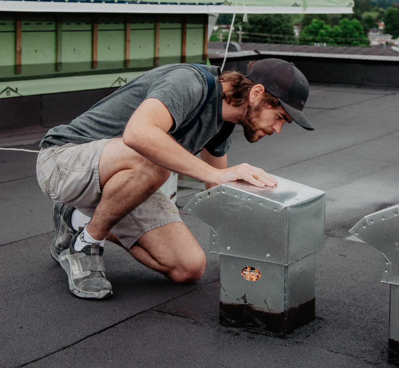 HVAC technician working on metal ductwork on a roof in Chilliwack, Fraser Valley, British Columbia.