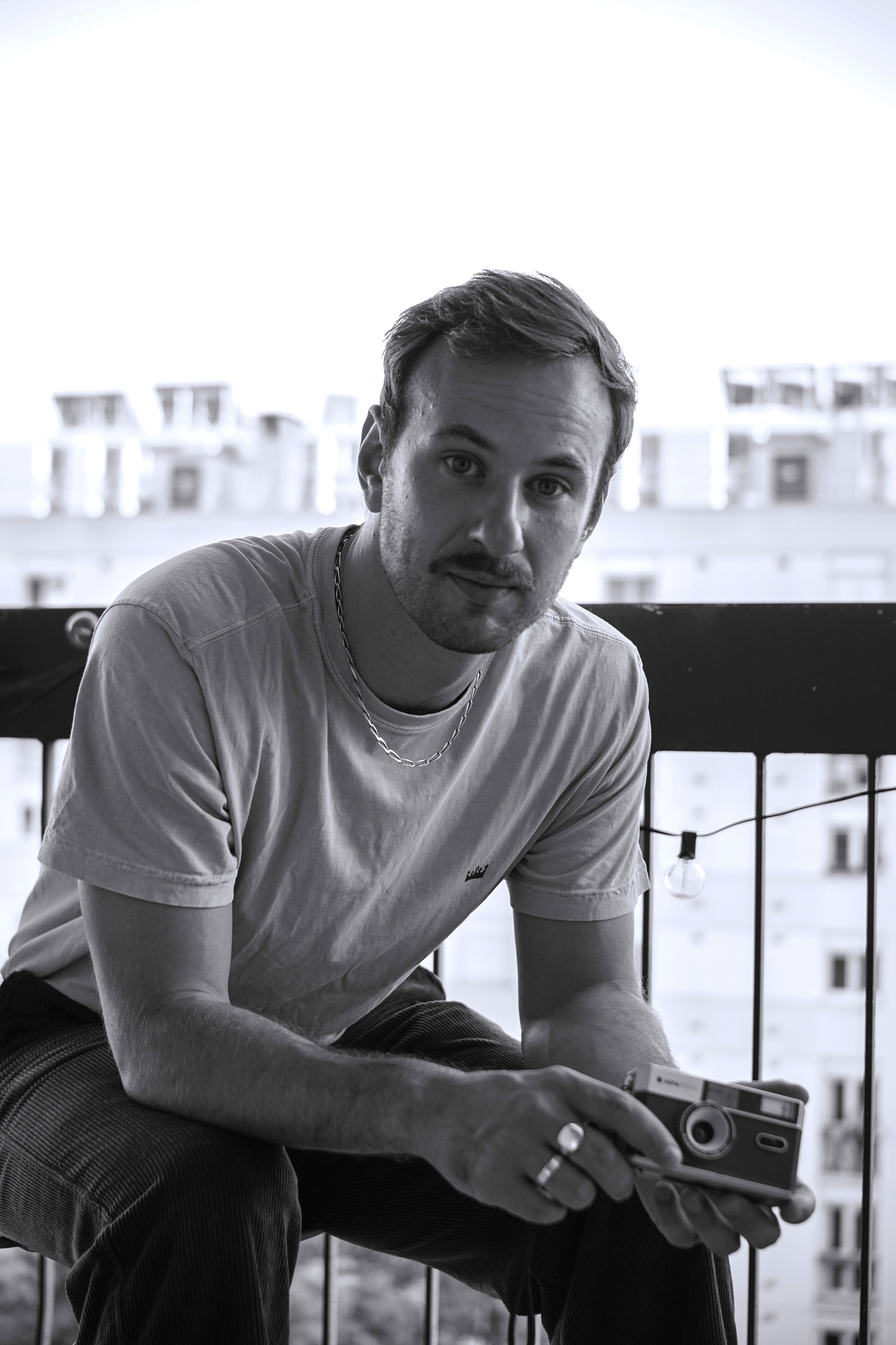 A view of a studio interior with modern decor, featuring large windows that offer a glimpse of lush greenery outside