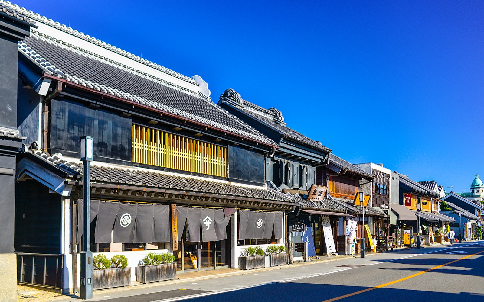 日本的西武园游乐园入口,五彩缤纷的游乐设施和游客。有西武铁路通票选项。