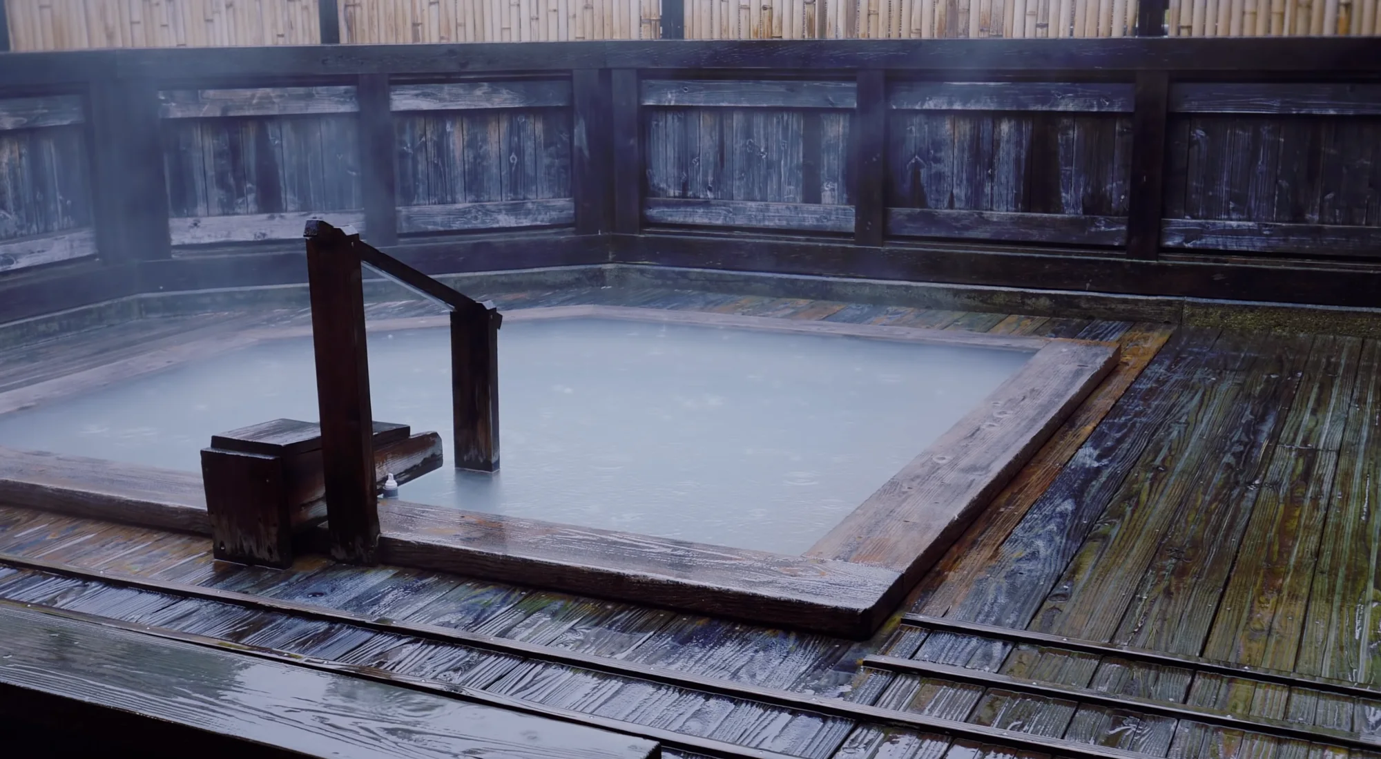 An open-air onsen bath under snow