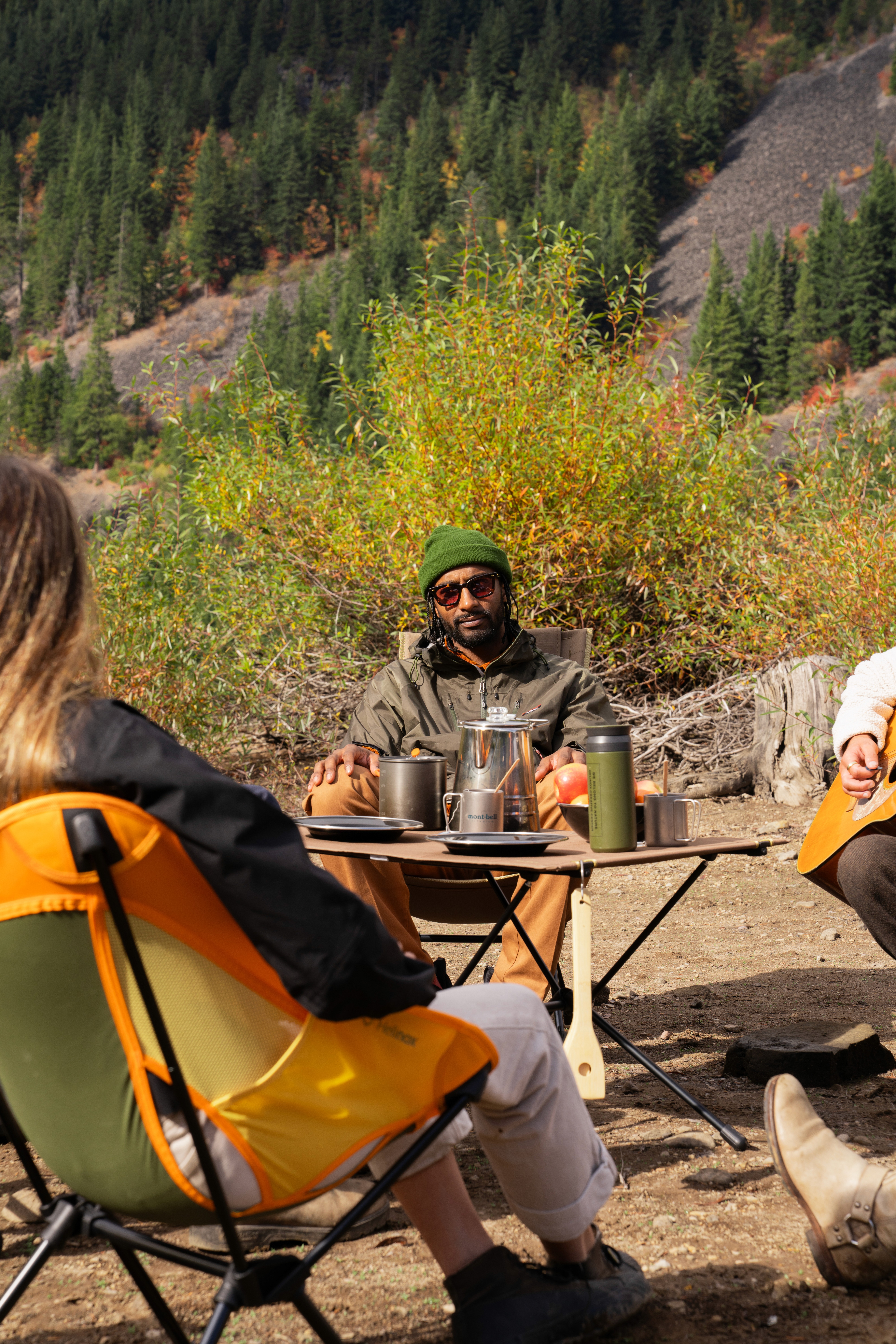 Des gens autour d'une table pliante et sur des chaises pliantes de camping de la marque Helinox