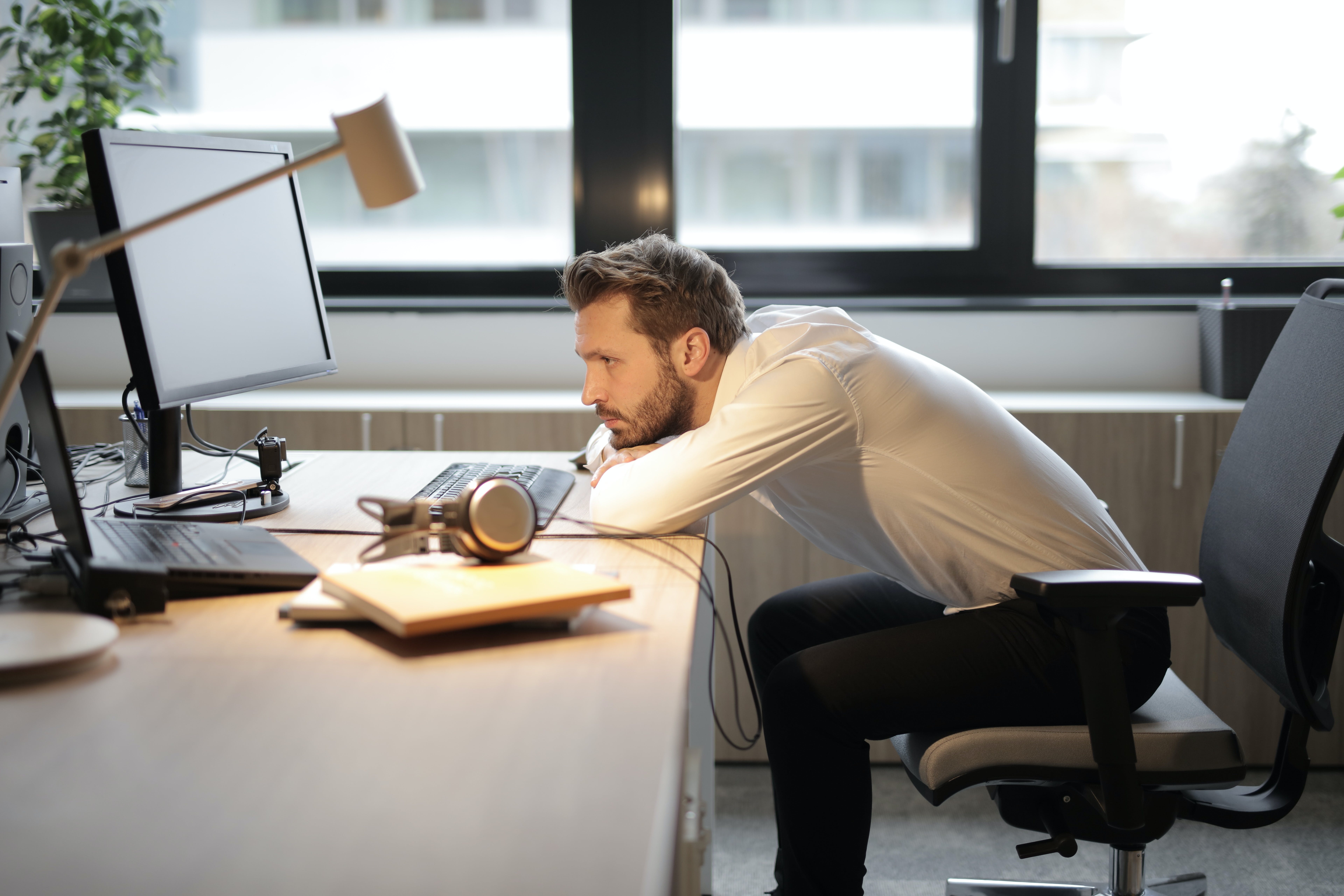 Man in white shirt sitting on chair reading others' cold emails