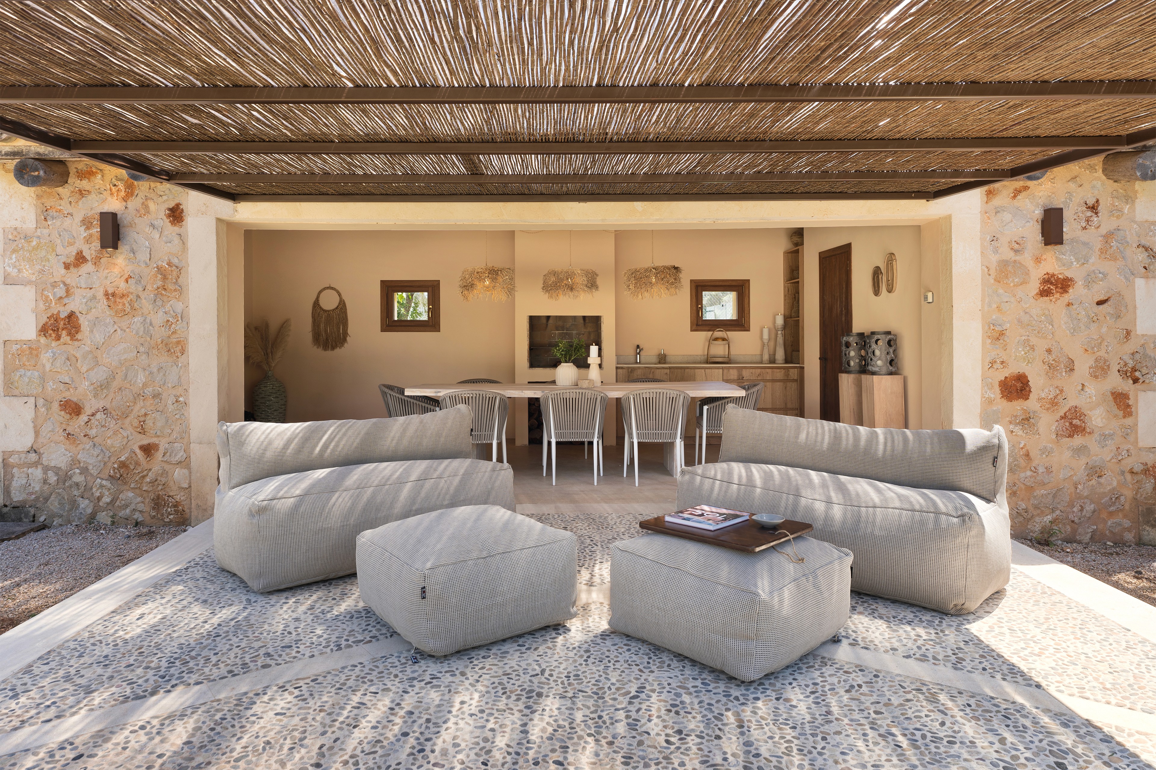 Poolhouse Finca Mallorca mit Loungemöbeln, Natursteinwand und überdachtem Aussenbereich