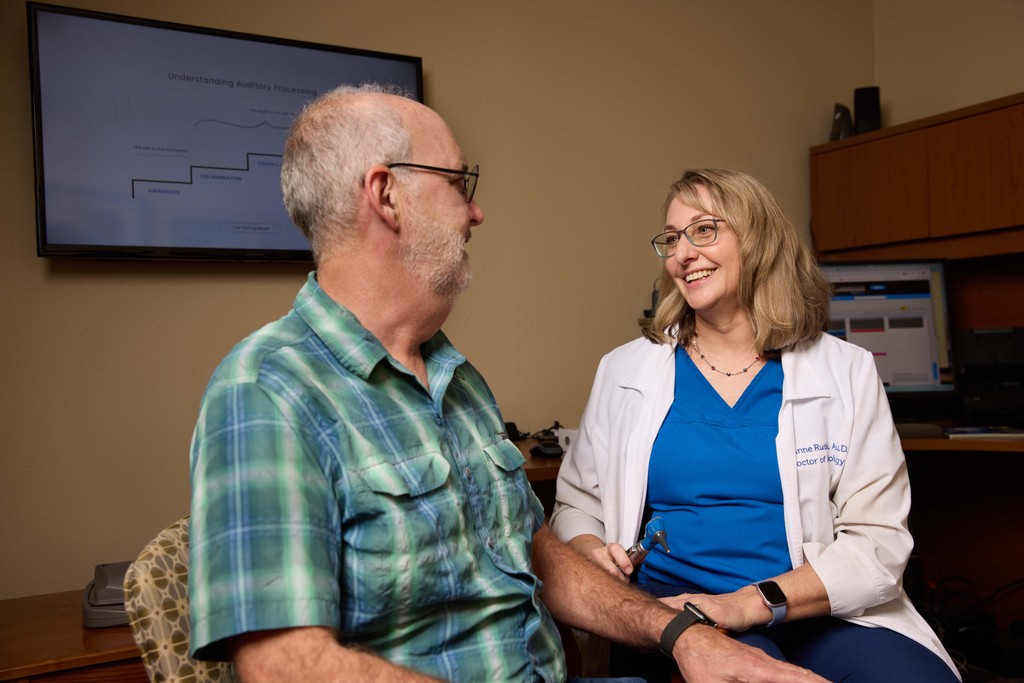 A healthcare professional and a patient engage in a conversation in a clinic setting.