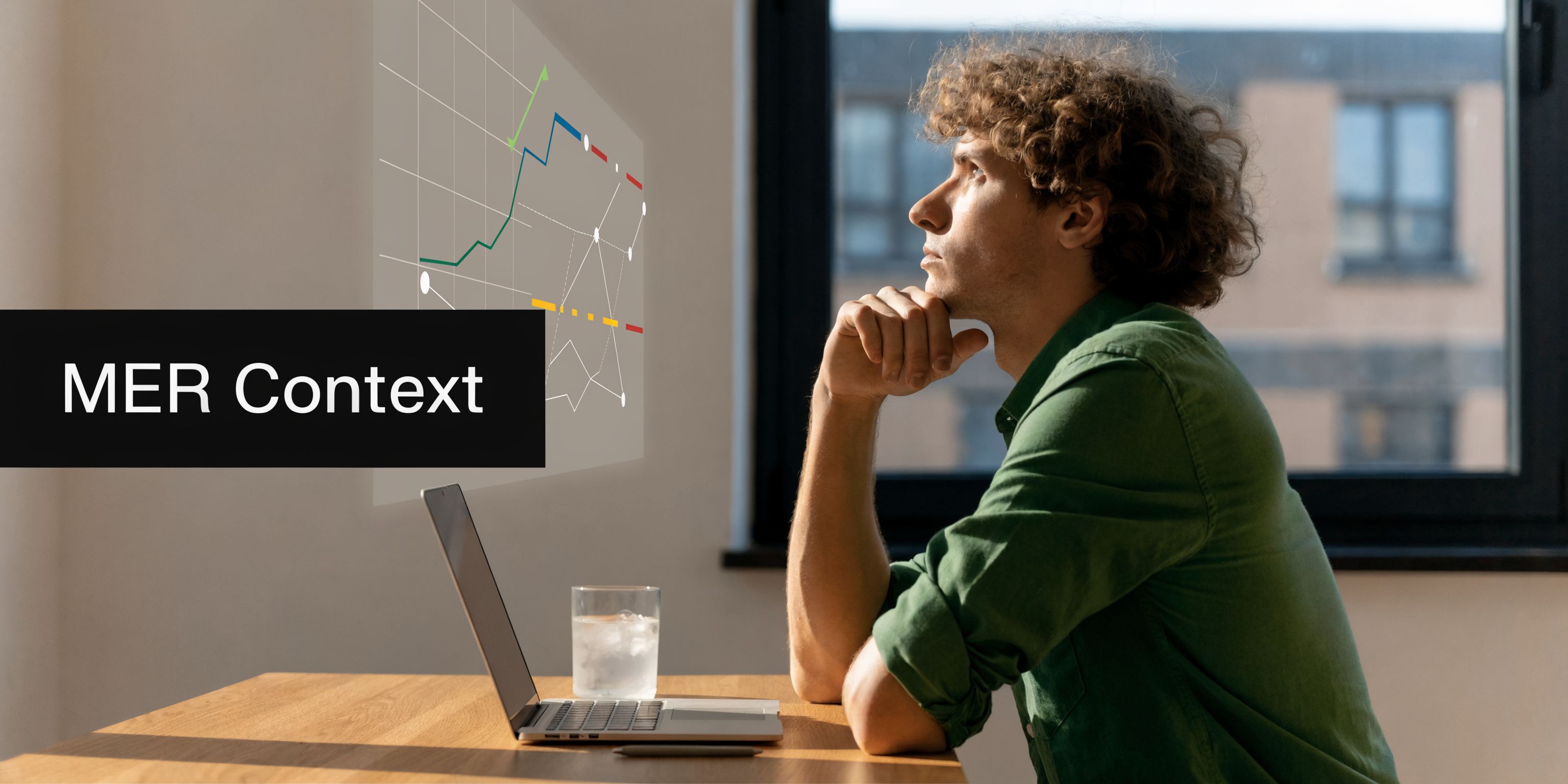 A young man sitting at a desk and thinking while looking at a digital data chart.