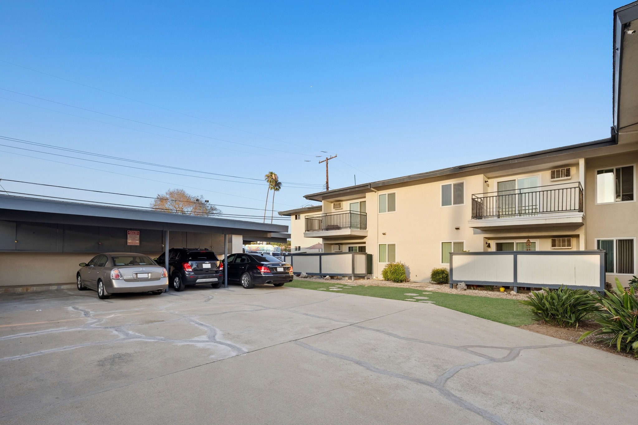 9025 Mills Avenue carport parking zone with multiple vehicle spaces and adjacent apartment units.