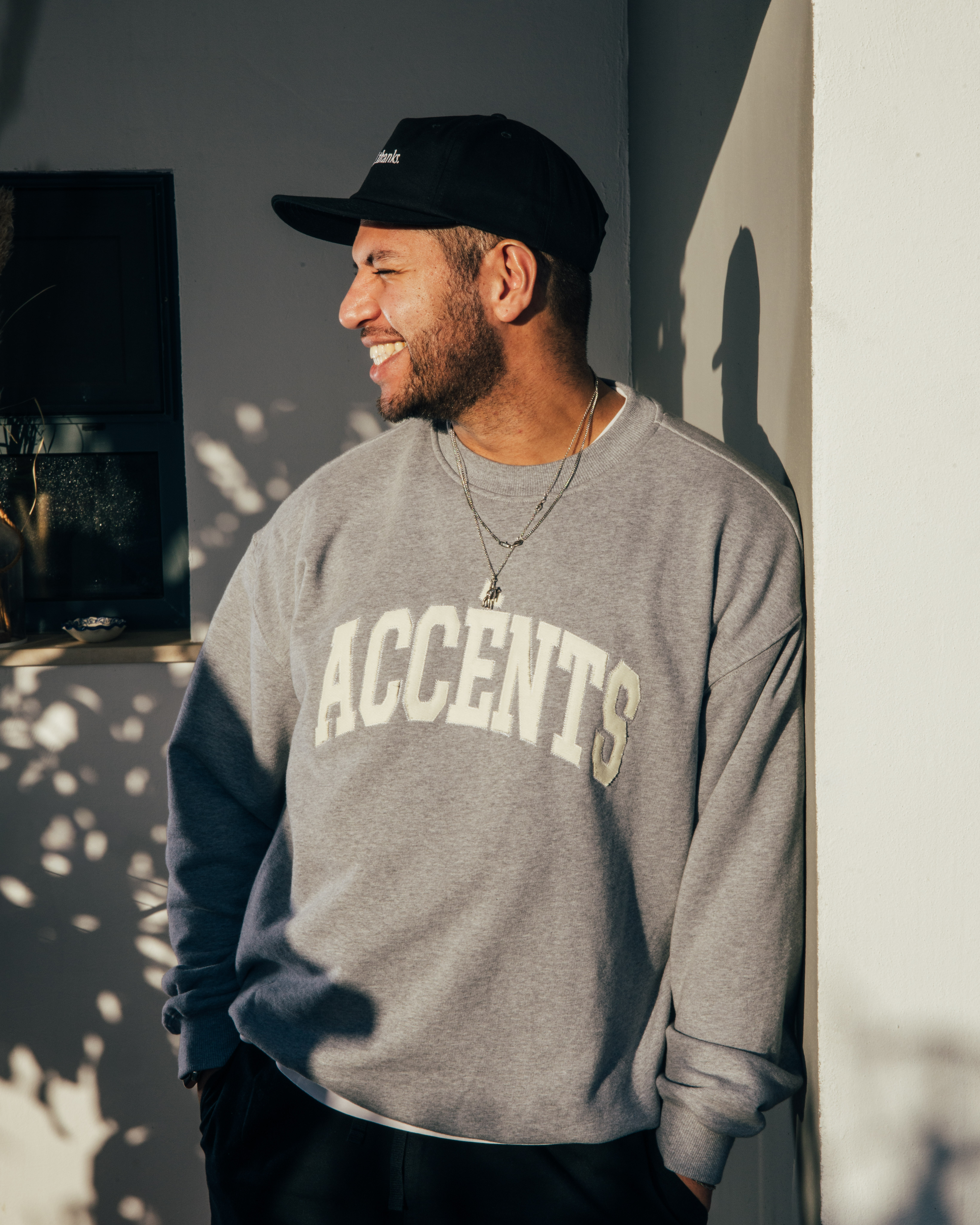 A thoughtful young person with dark hair gazes to the side, captured in soft black and white lighting.