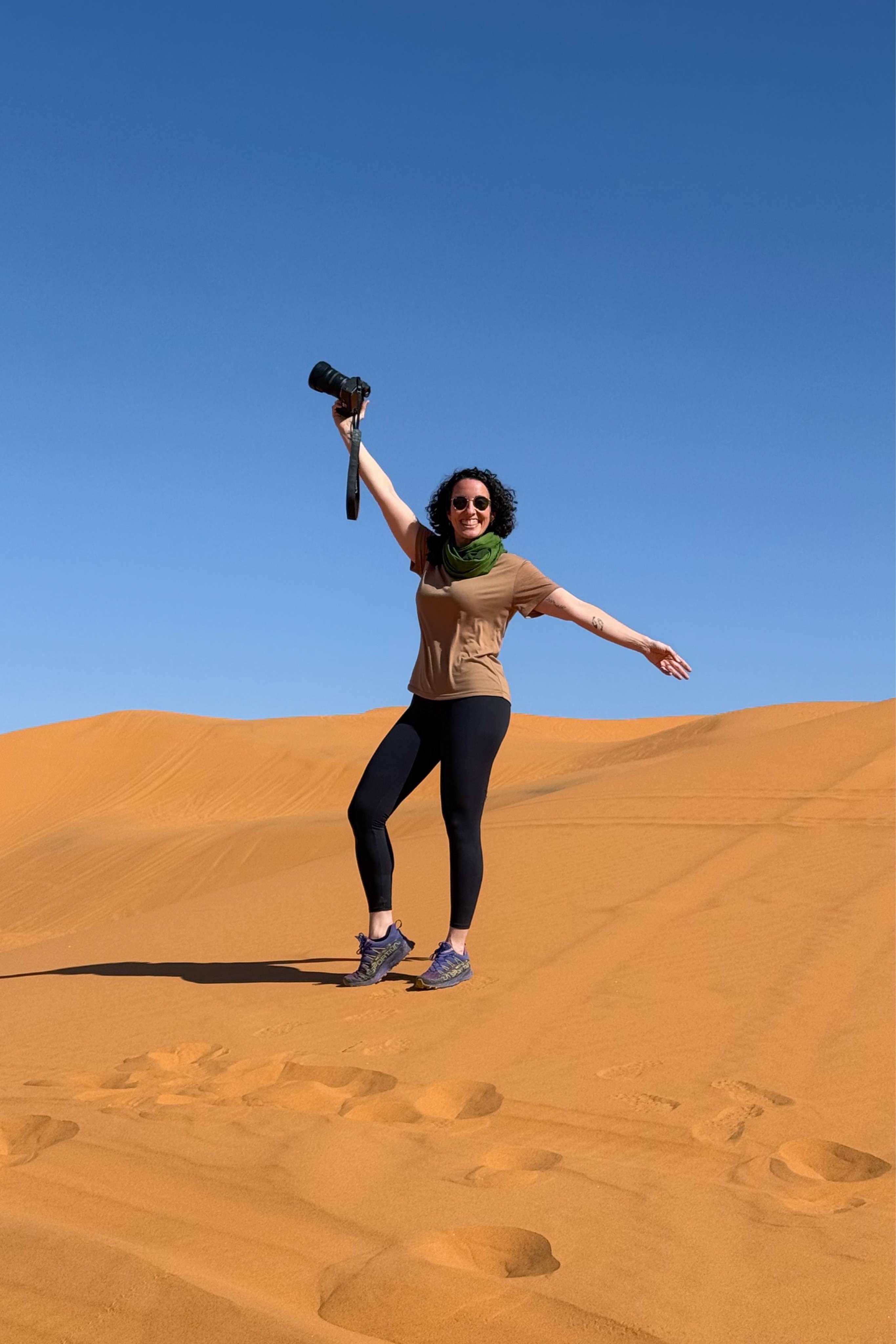 Two green boats anchored near rocky shore and breakwater.