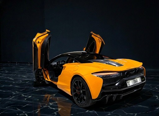 McLaren Artura 2024 orange rear left exterior showcasing hybrid supercar design by Queen of Supercar Rental