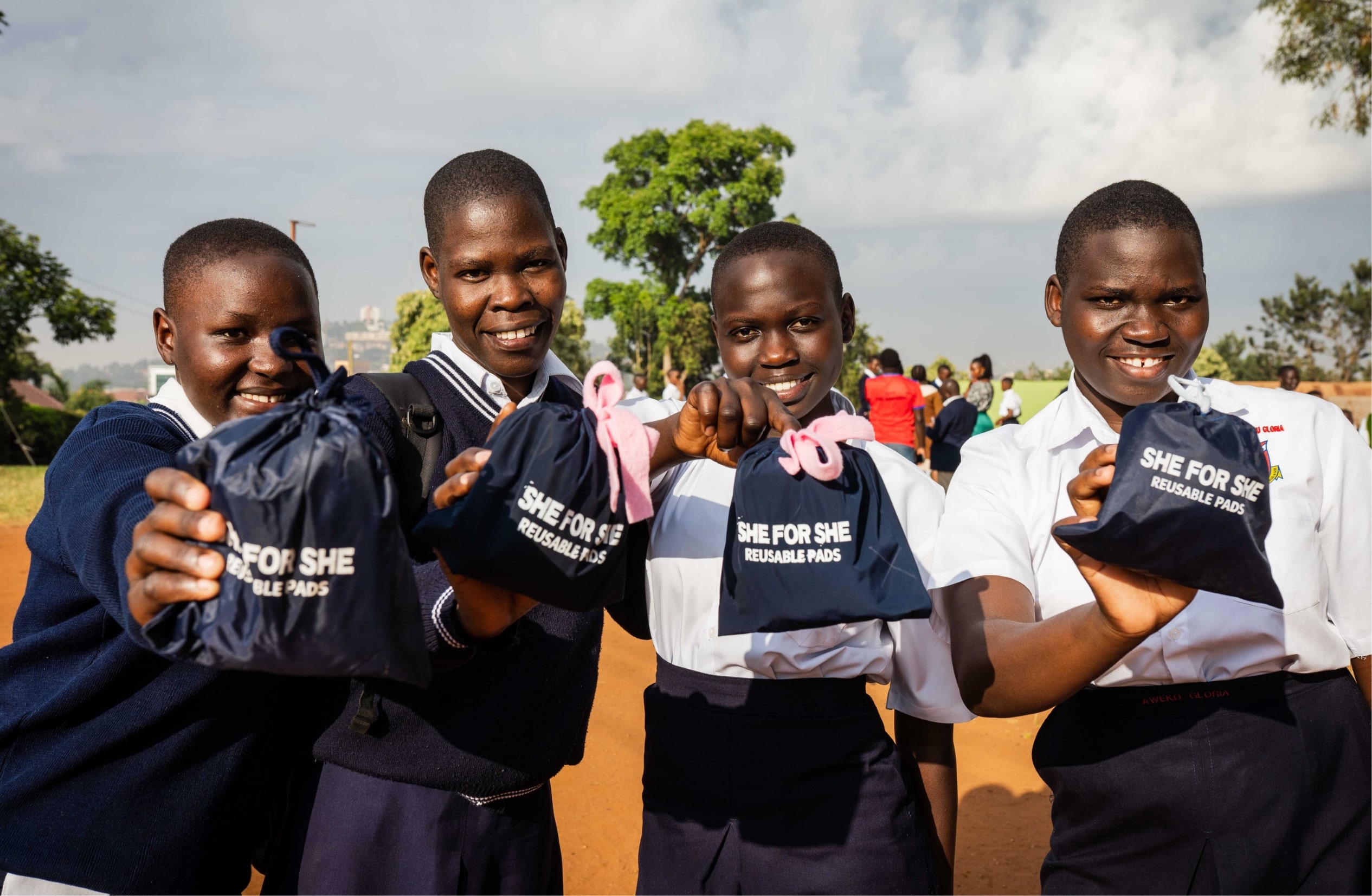 Phiona and other girls holding reusable menstruation pads.