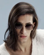 A model with brown hair wearing sunglasses.