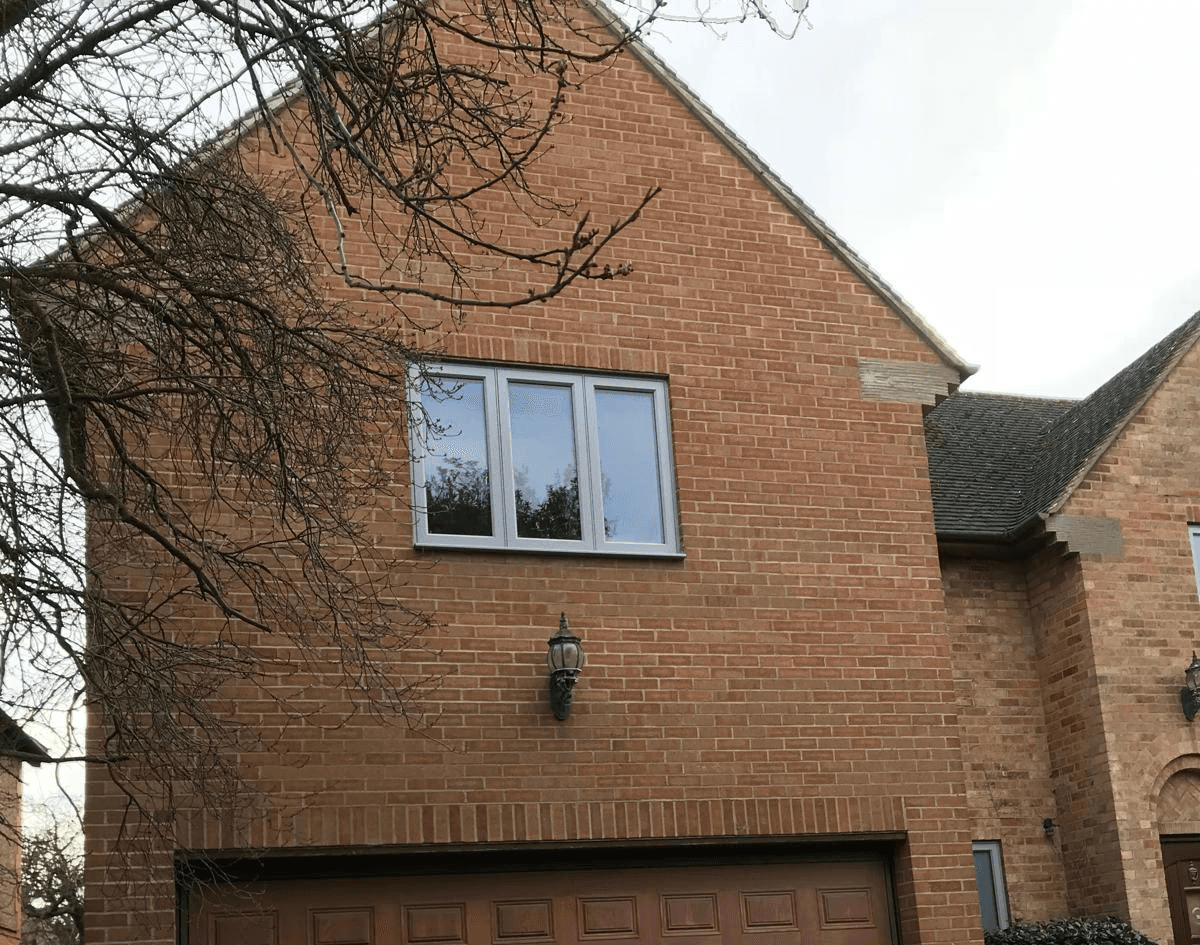 Close-up of newly installed grey-framed windows on a brick home by PPM Builders in Northampton.
