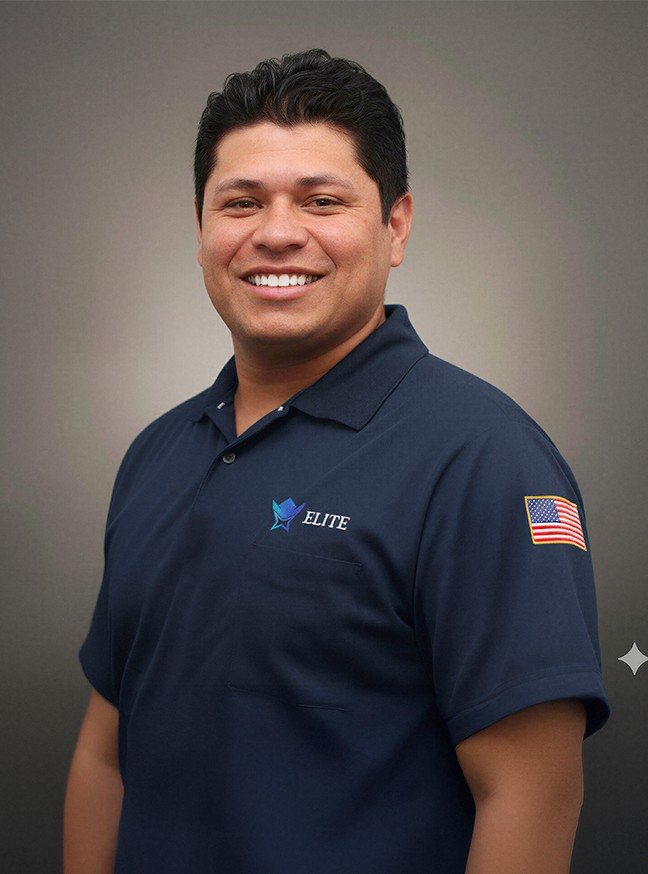 A man with glasses and a brown shirt, crossing his arms.