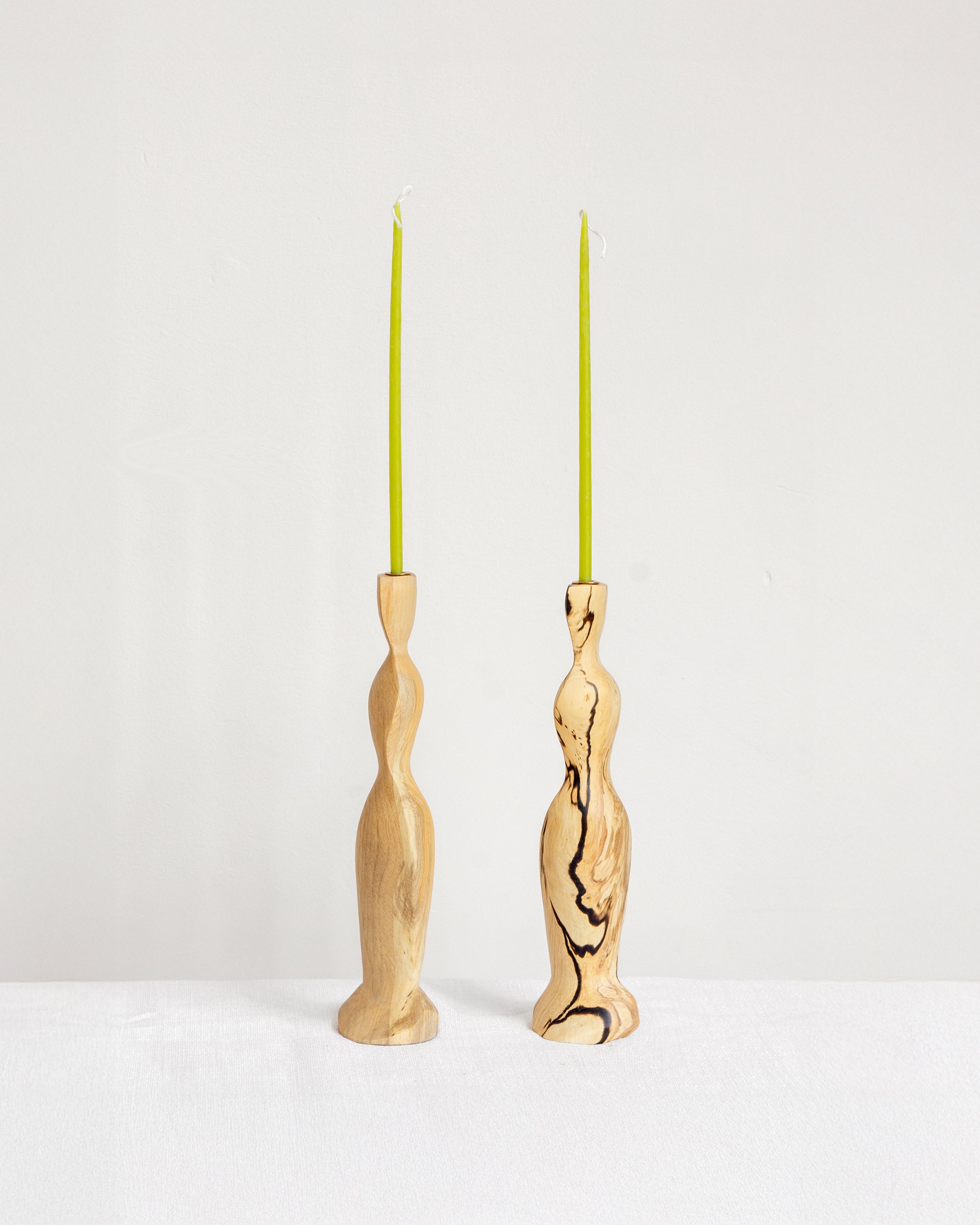 Figura Candlestick holders in Spalted on white background with green candles