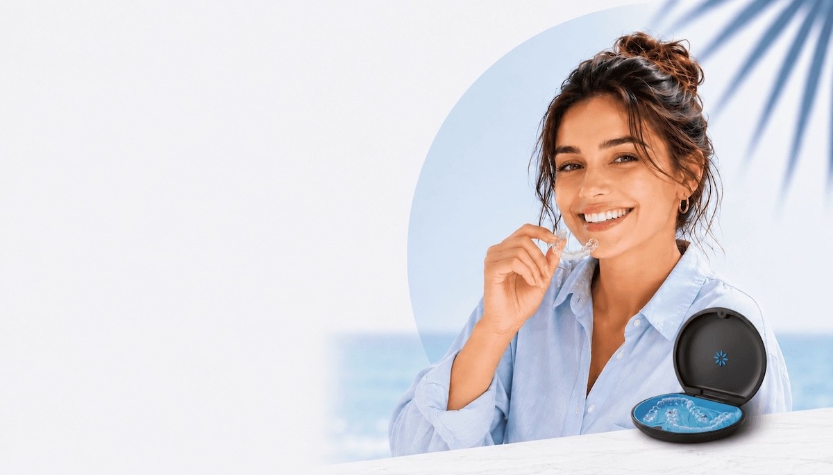 Smiling girl in blue shirt inserting Invisalign clear aligners, enjoy the summer offer now at Invisalign Center Dubai.