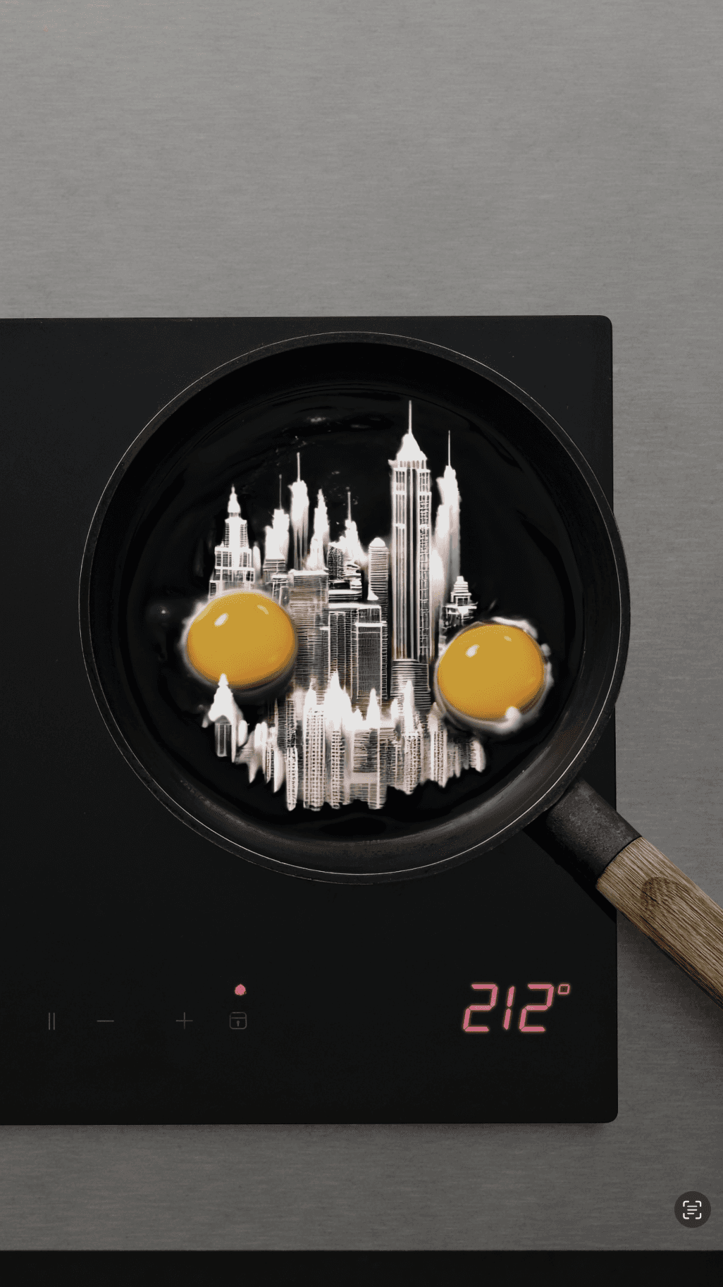 An overhead shot of a frying pan on a digital stove containing two eggs and a white miniature city