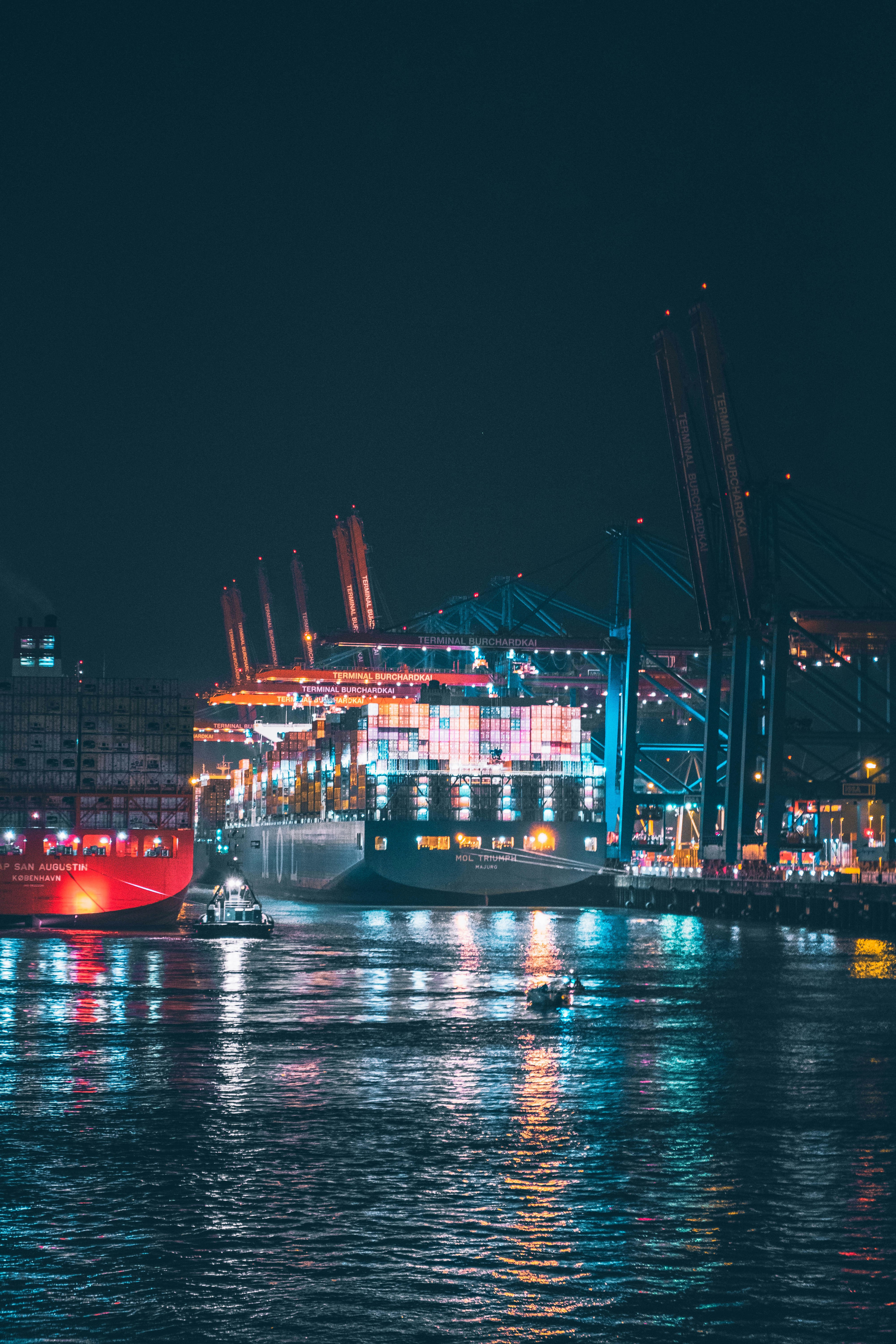 red and white cargo ship on dock during night time