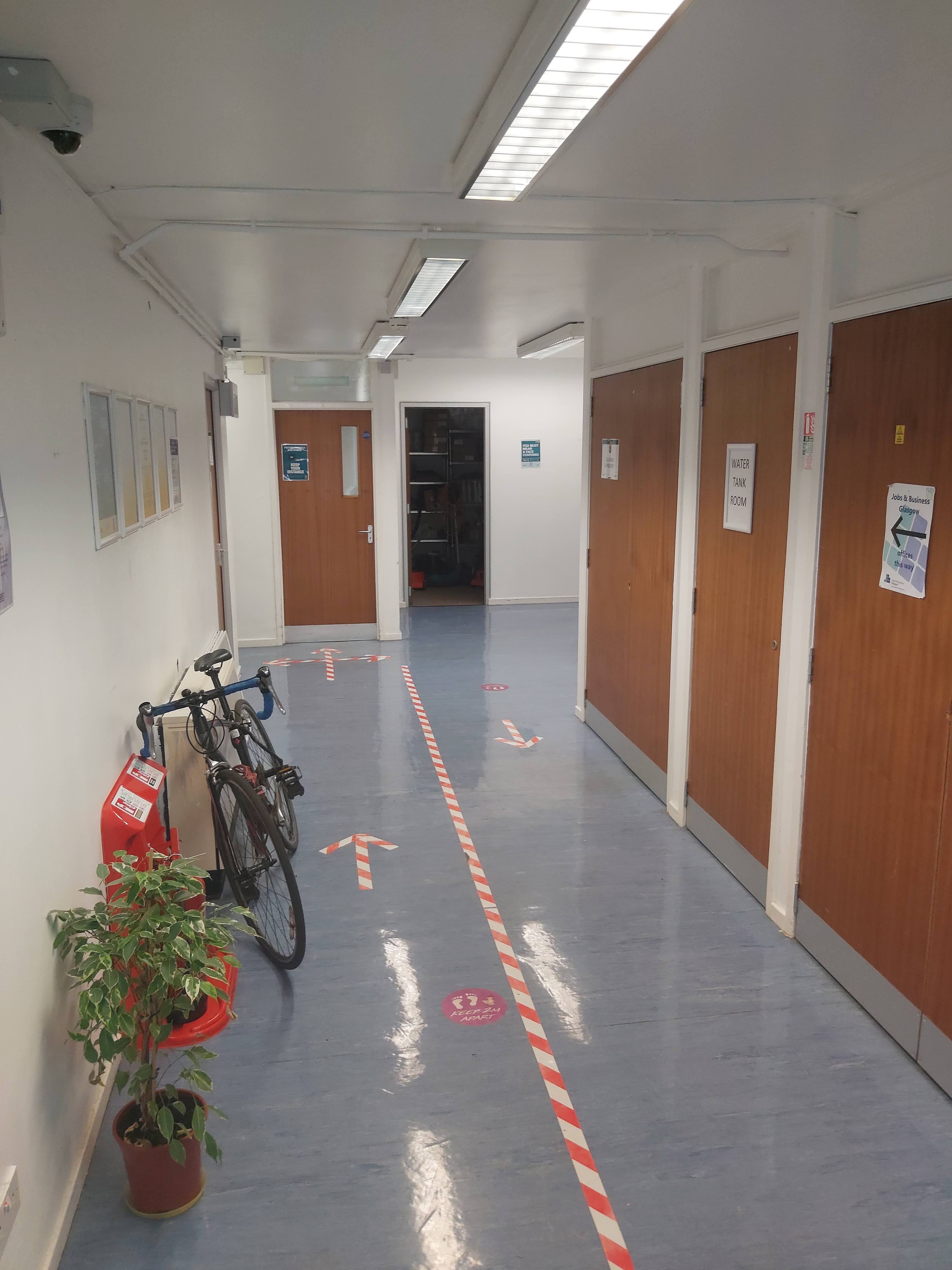 A narrow hallway with wooden doors leading into seperate rooms