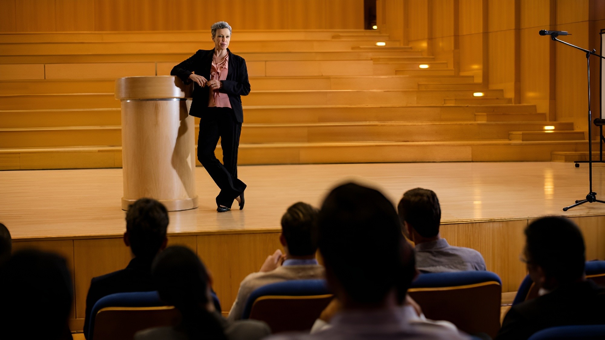 Presenter speaking to an audience in a lecture hall