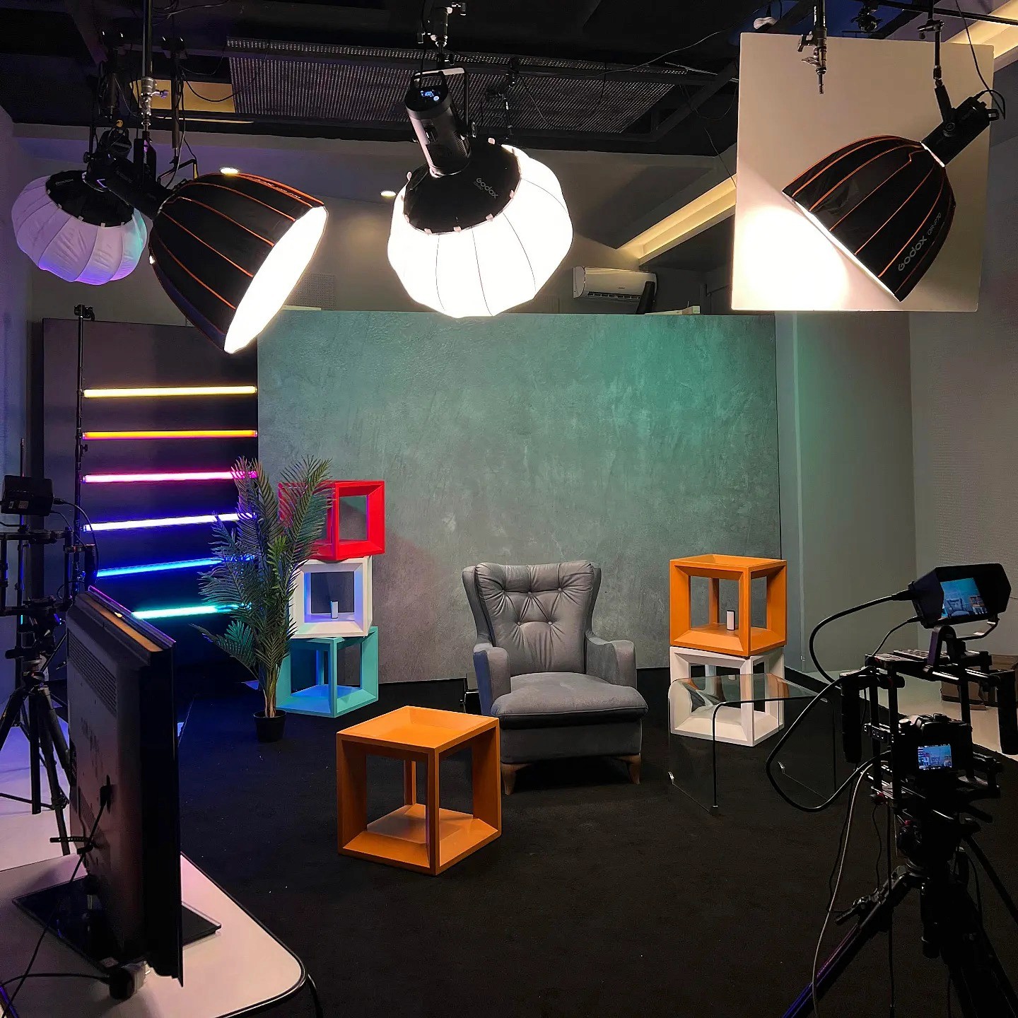 Black and white image of people working at a table with laptops, showing hands gesturing during discussion of digital content displayed on screens, with fabrica® logo in the corner.