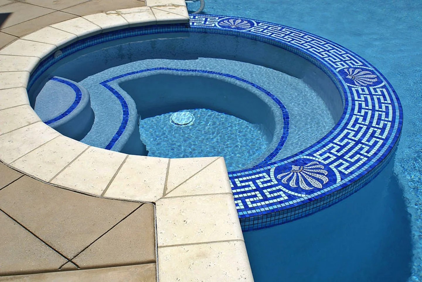 Greek key waterline mosaic border with shell medallions in hand-cut blue and white glass, curving around a spa at a San Diego residence