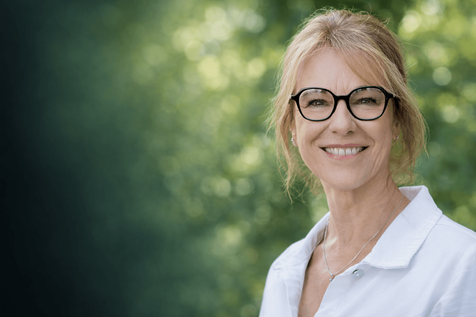 woman in blue tank top standing beside white wall