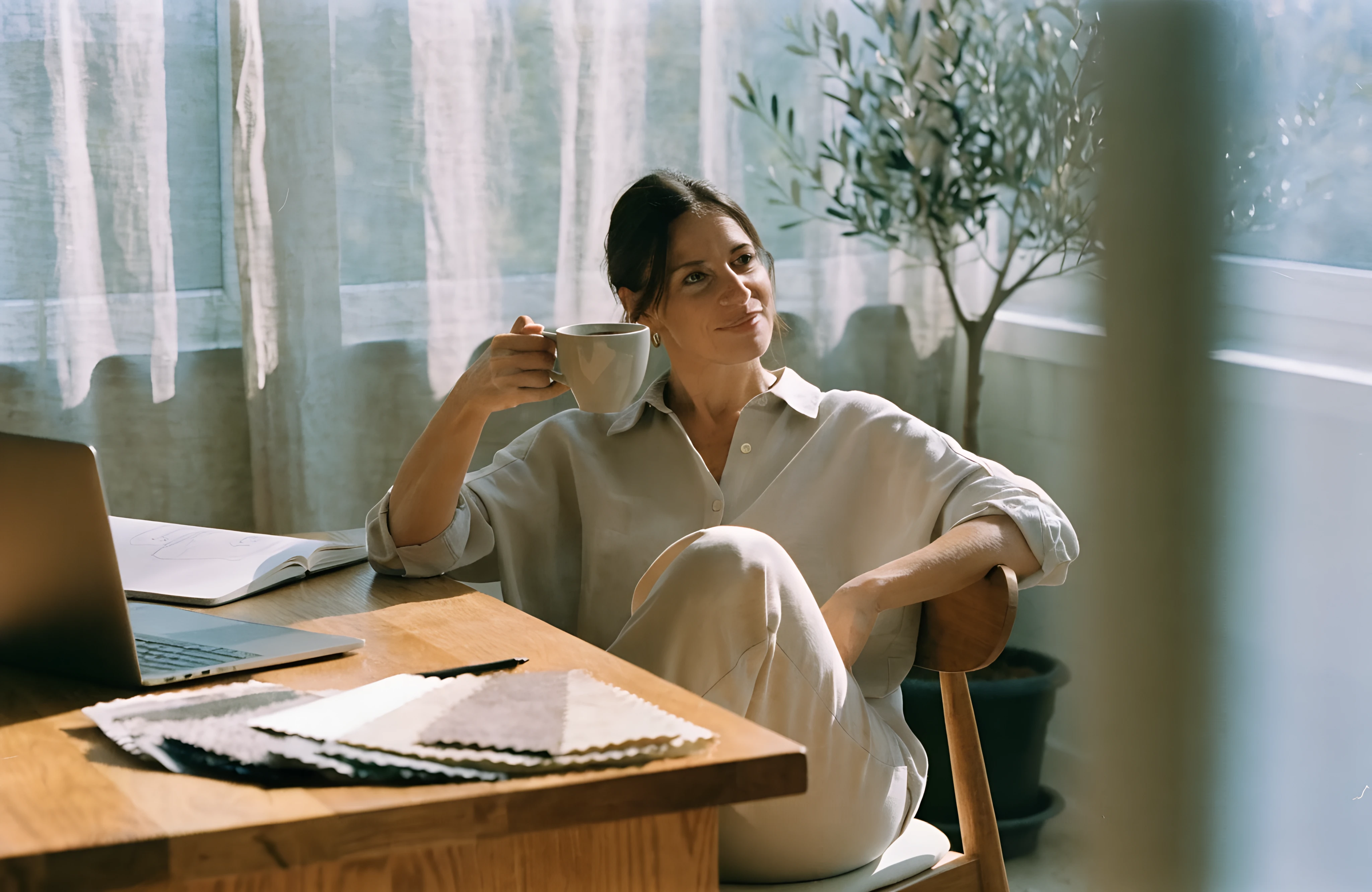 Interior designer relaxed at her desk, proud to make her business look professional online