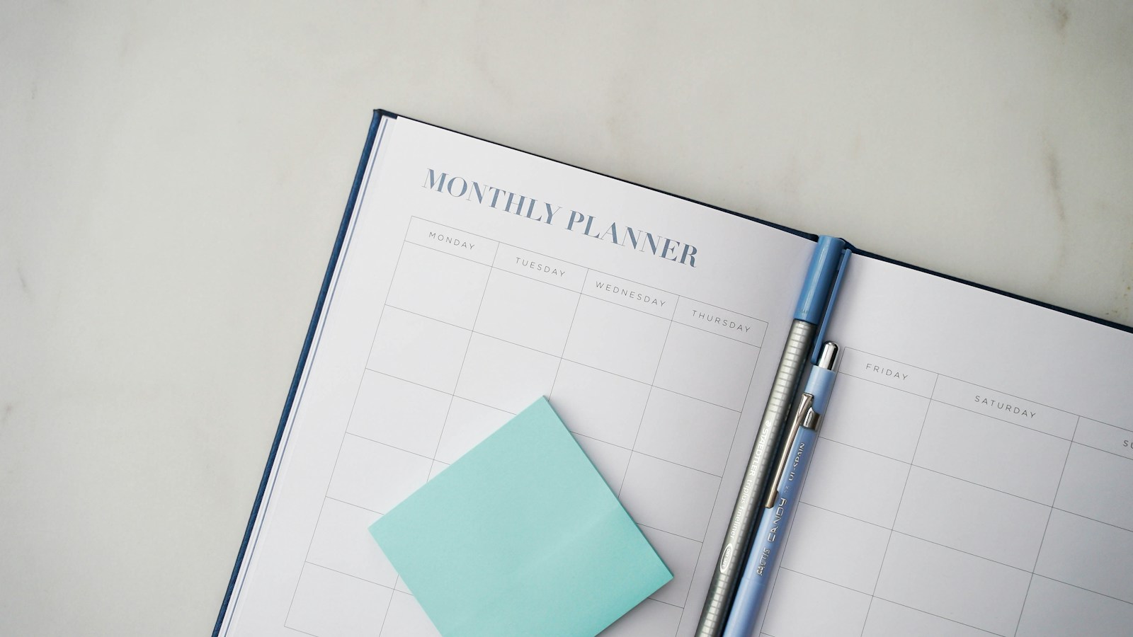 A planner with a pen resting on top