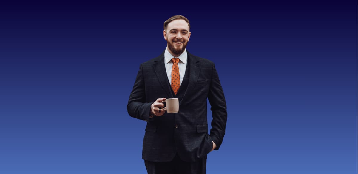 A man in a suit. He's smiling, has short hair and a beard