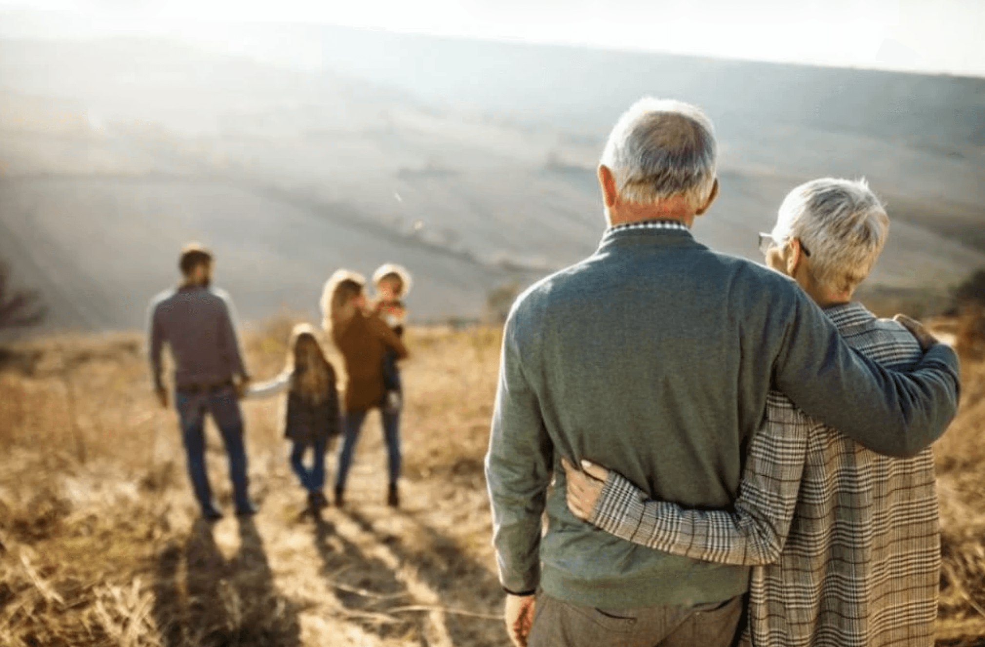 Elderly couple looking out at family
