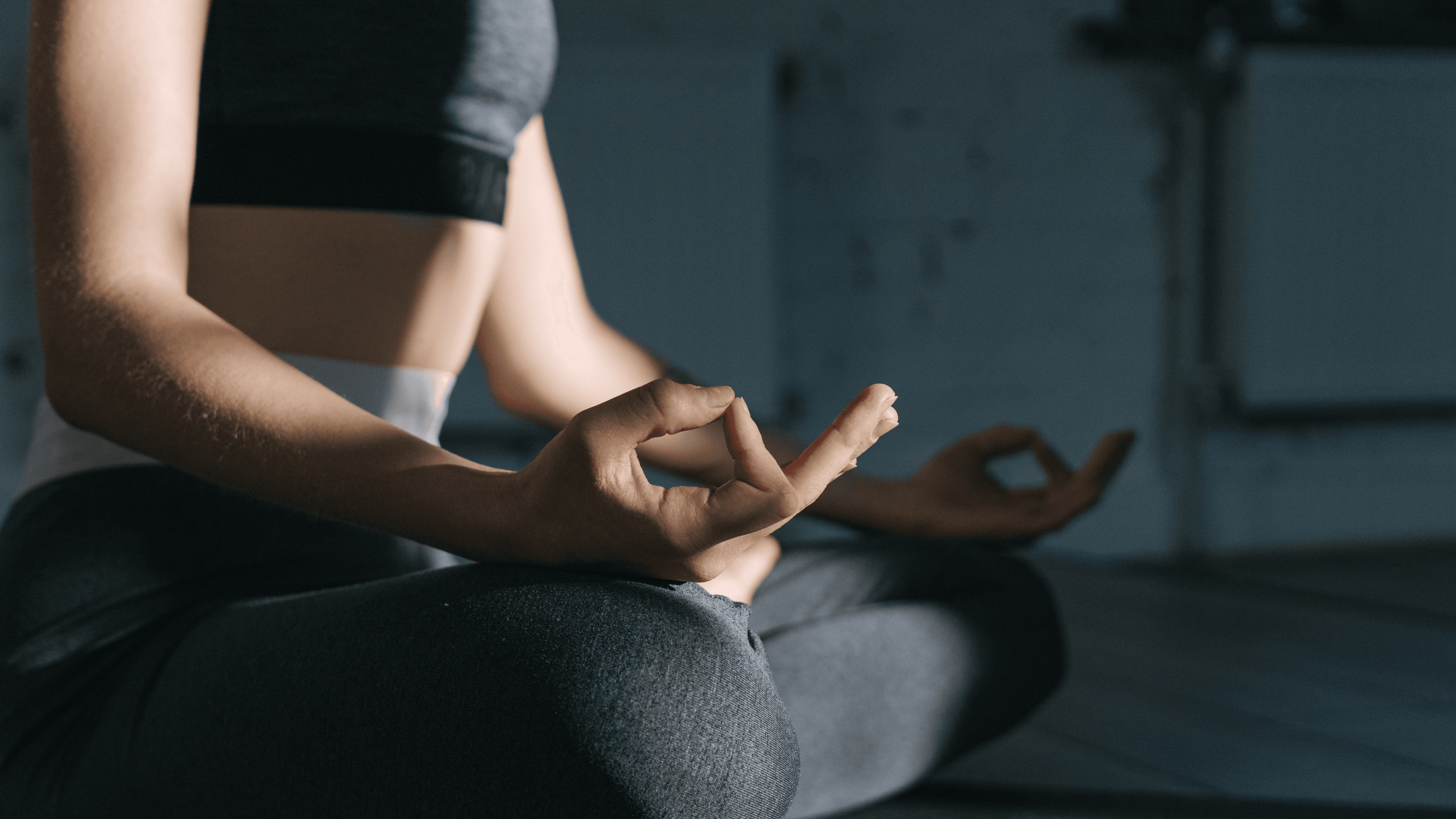 A person with curly hair sits at a desk, working on a laptop in a cozy, well-lit environment.