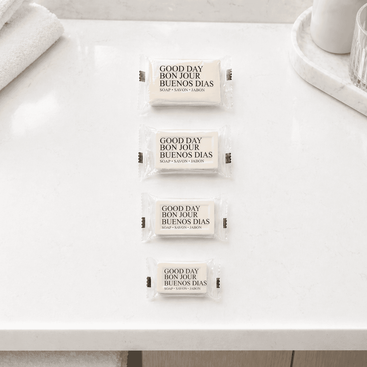 Good Day luxury hotel bar soap collection in multiple sizes by Transmacro Amenities, displayed on a modern marble vanity