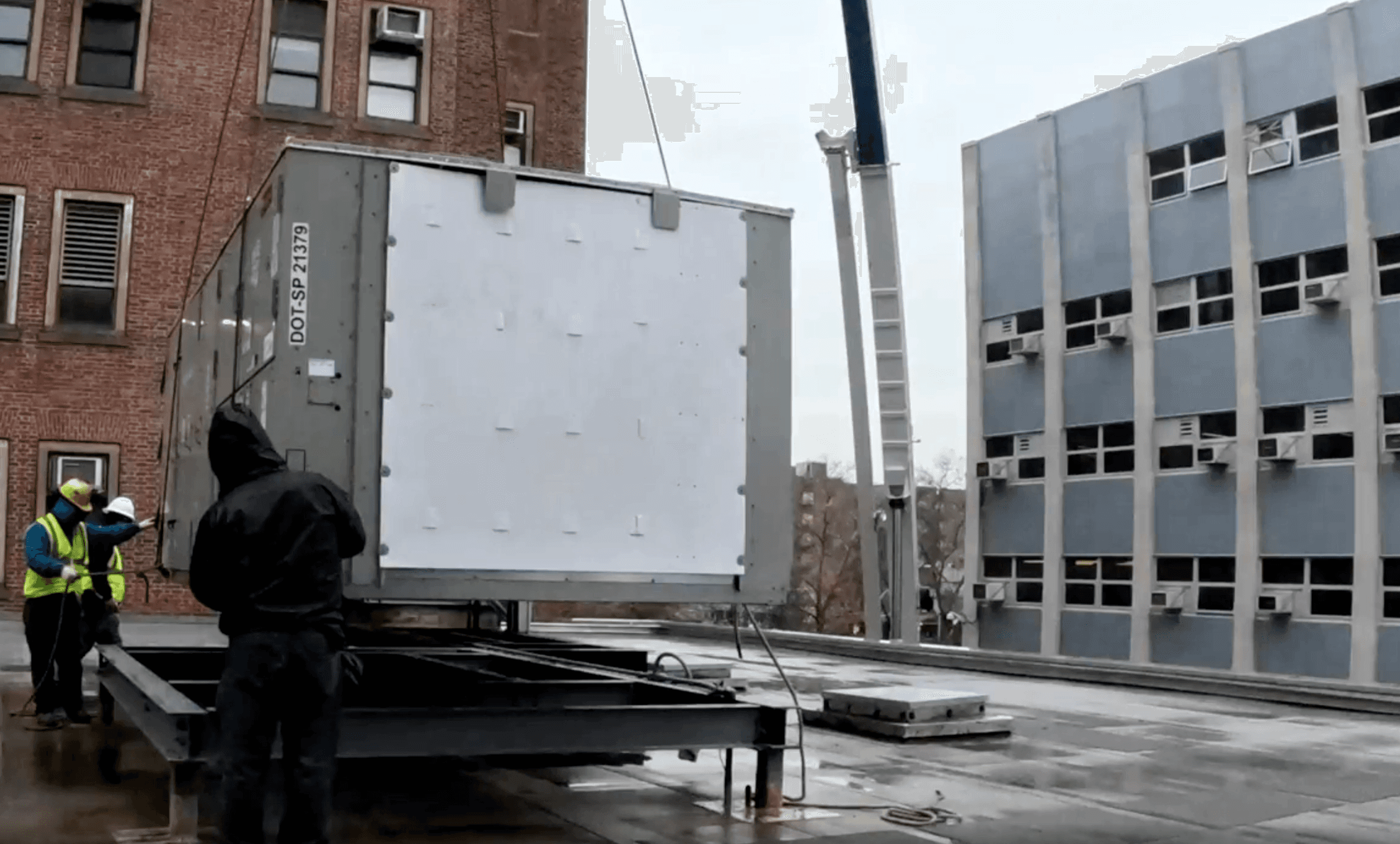 Crane lifting a rooftop HVAC unit during replacement at Kings County Hospital.