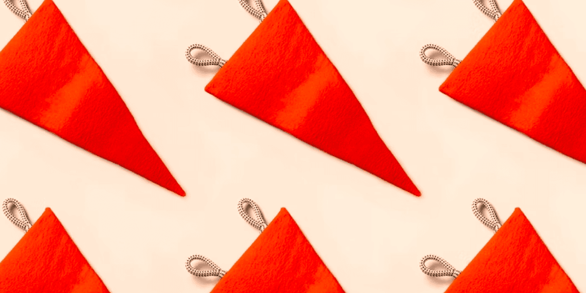 Repeating pattern of red-orange triangular pendant flags on a light cream background
